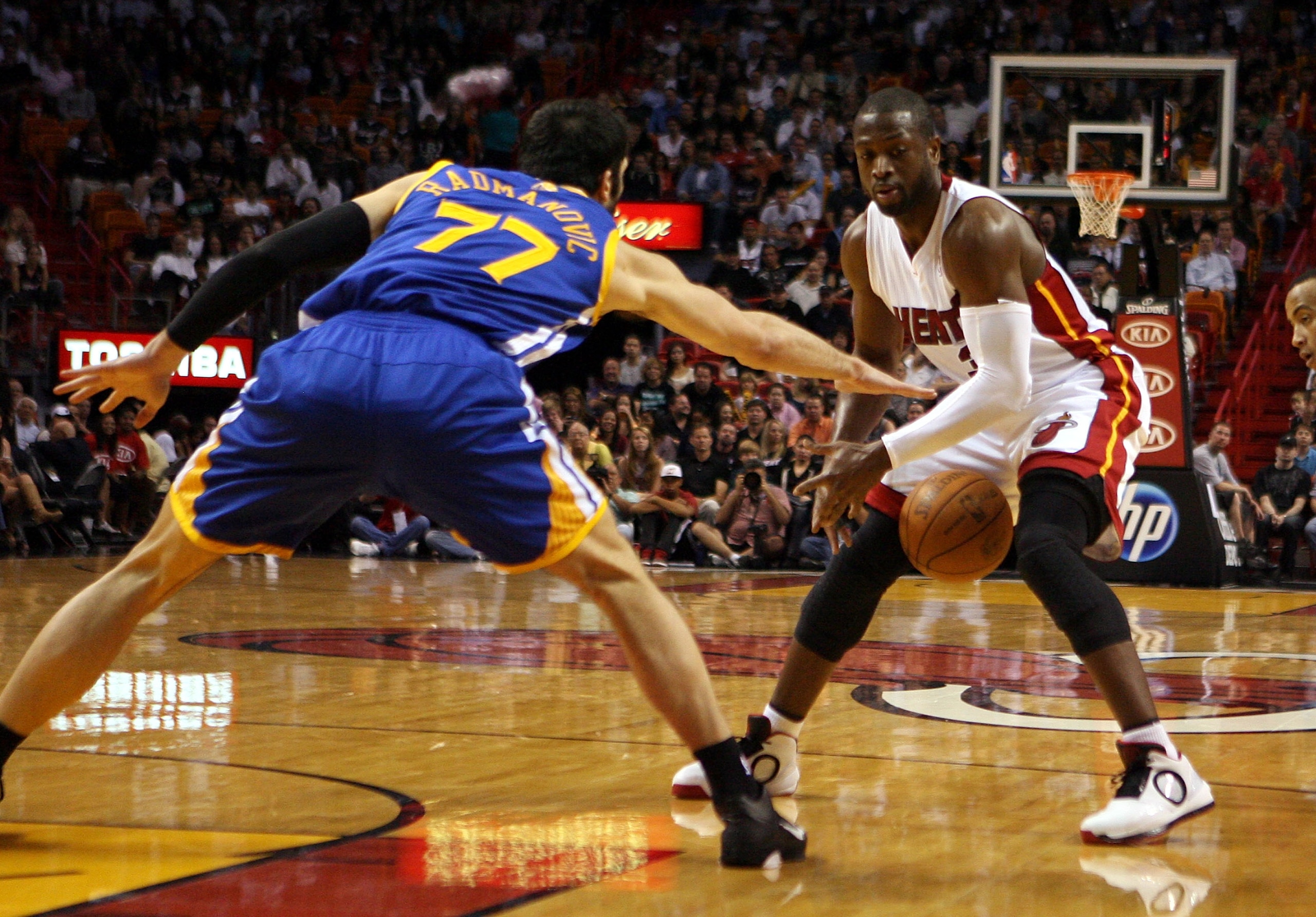 MIAMI, FL - JANUARY 01:  Guard Dwyane Wade #3 of the Miami Heat is fouled by forward Vladimir Radmanovic #77 of the Golden State Warriors at American Airlines Arena on January 1, 2011 in Miami, Florida.  NOTE TO USER: User expressly acknowledges and agree