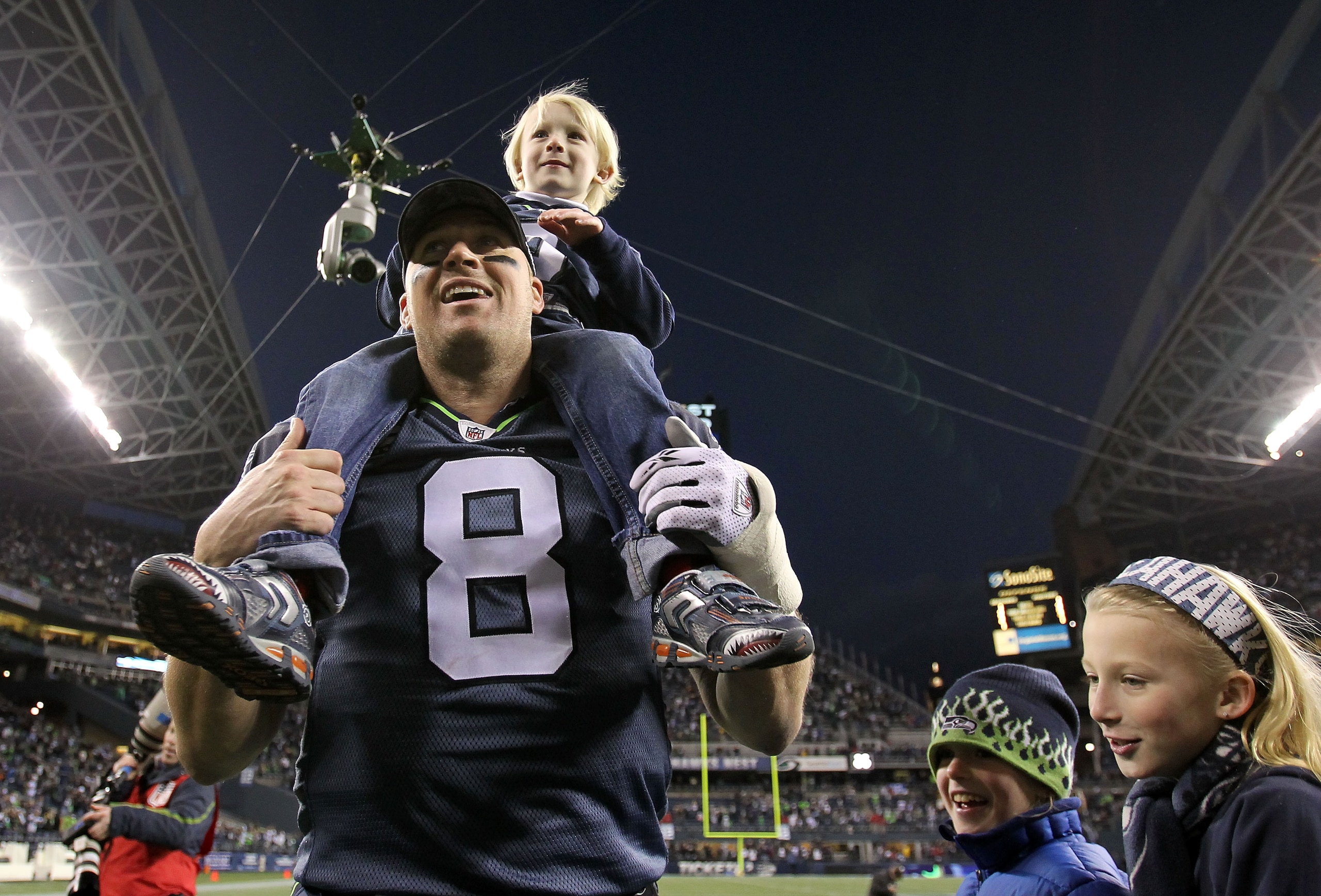SEATTLE, WA - JANUARY 08:  Quarterback Matt Hasselbeck #8 of the Seattle Seahawks celebrates the Seahawks 41-36 victory against the New Orleans Saints as his son Henry Hasselbeck is carried off on his back after the 2011 NFC wild-card playoff game at Qwes