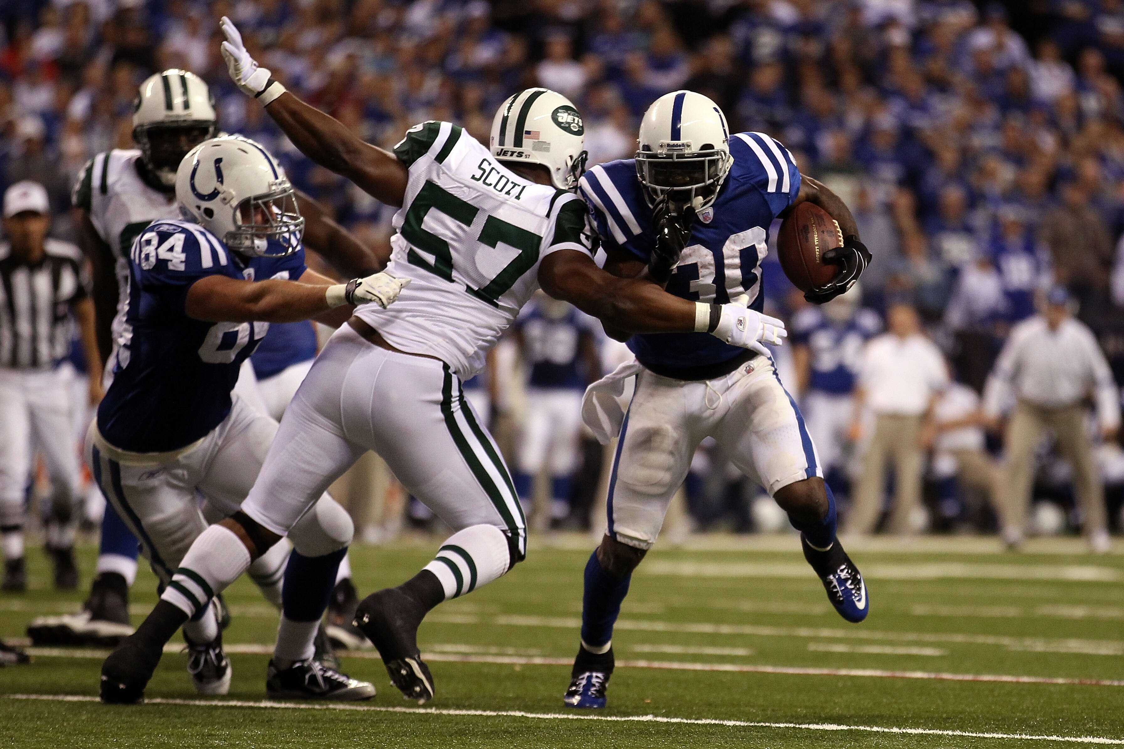 INDIANAPOLIS, IN - JANUARY 08: Dominic Rhodes #30 of the Indianapolis Colts runs the ball against Bart Scott #57 of the New York Jets during their 2011 AFC wild card playoff game at Lucas Oil Stadium on January 8, 2011 in Indianapolis, Indiana.  (Photo by