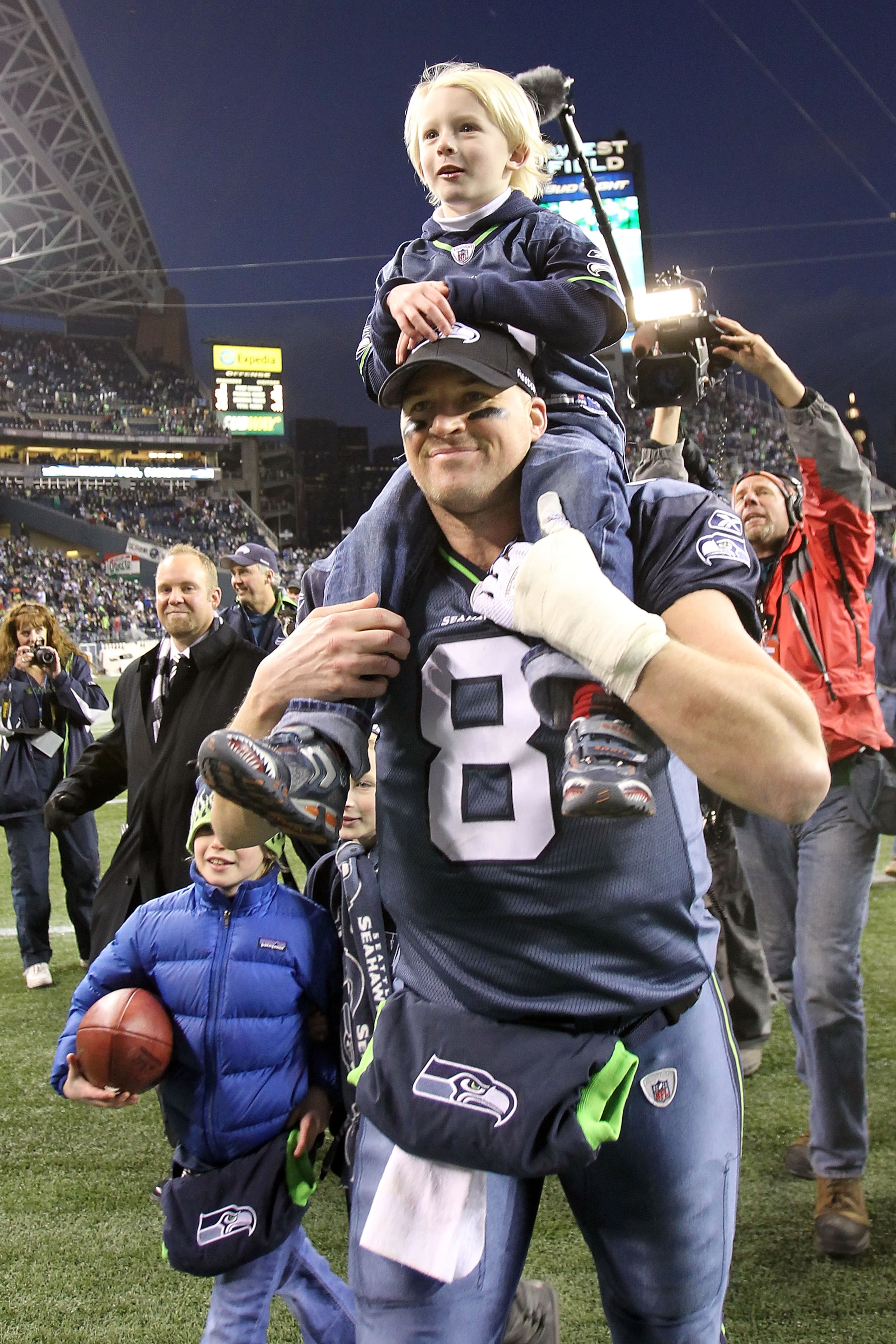 SEATTLE, WA - JANUARY 08:  Quarterback Matt Hasselbeck #8 of the Seattle Seahawks celebrates the Seahawks 41-36 victory against the New Orleans Saints as his son Henry Hasselbeck is carried off on his back after the 2011 NFC wild-card playoff game at Qwes