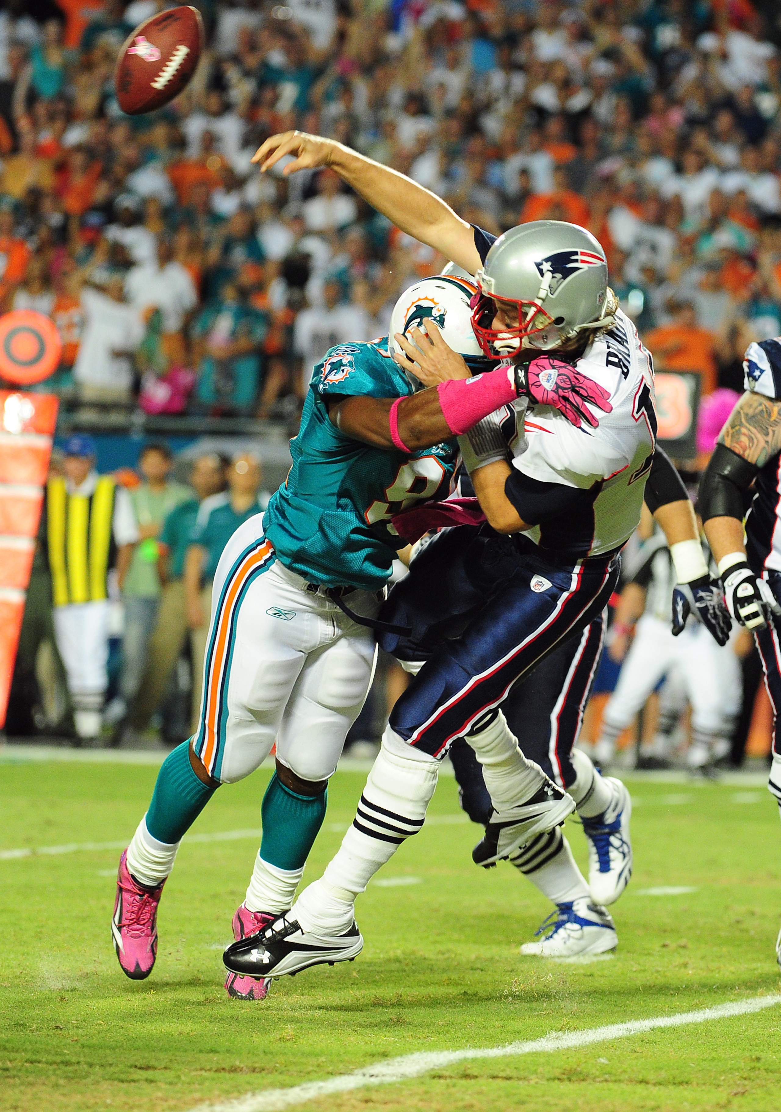 MIAMI - OCTOBER 4: Tom Brady #12 of the New England Patriots is hit as he passes by Cameron Wake #91 of the Miami Dolphins at Sun Life Field on October 4, 2010 in Miami, Florida. (Photo by Scott Cunningham/Getty Images)