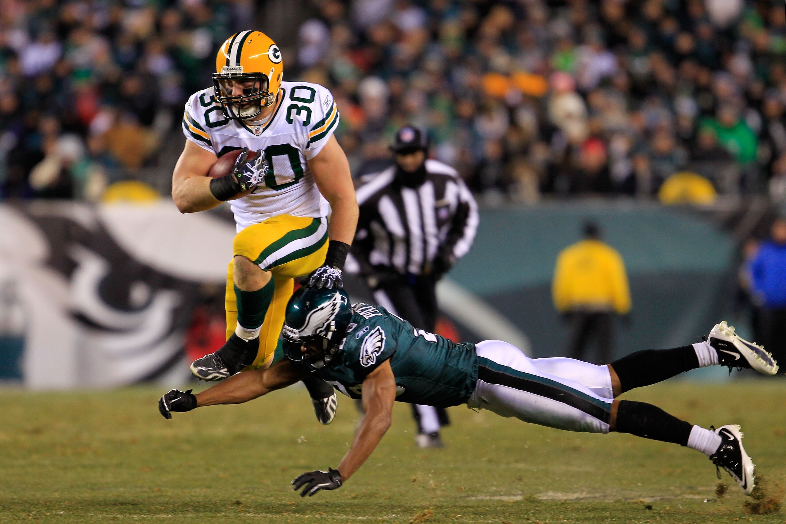 PHILADELPHIA, PA - JANUARY 09:  John Kuhn #30 of the Green Bay Packers avoids the tackle of Dimitri Patterson #23 of the Philadelphia Eagles during the 2011 NFC wild card playoff game at Lincoln Financial Field on January 9, 2011 in Philadelphia, Pennsylv