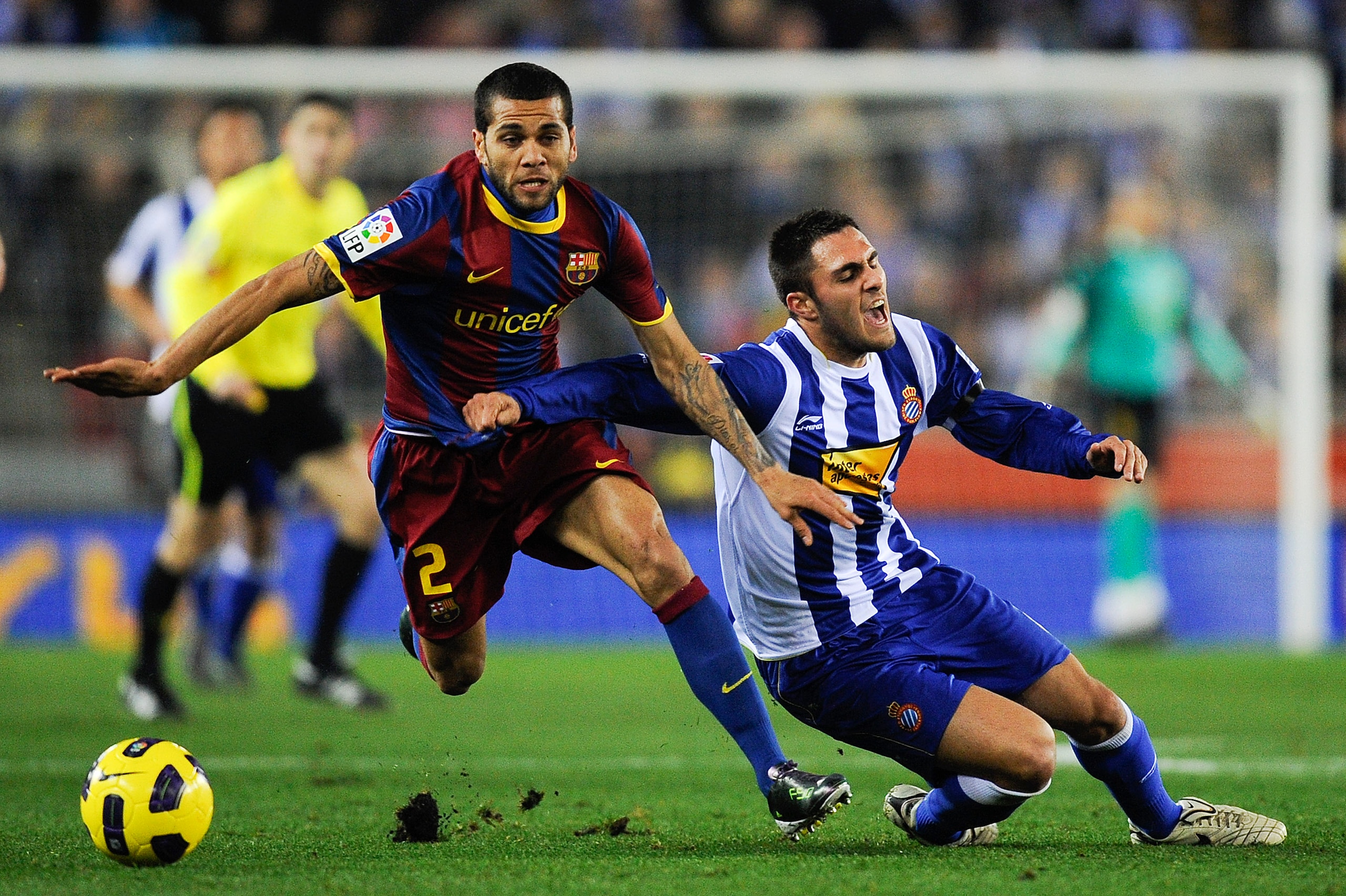BARCELONA, SPAIN - DECEMBER 18: Dani Alves of Barcelona (L) and Victor Ruiz of Espanyol duel for a ball during the La Liga match between Espanyol and Barcelona at Cornella - El Prat stadium on December 18, 2010 in Barcelona, Spain. Barcelona won the match