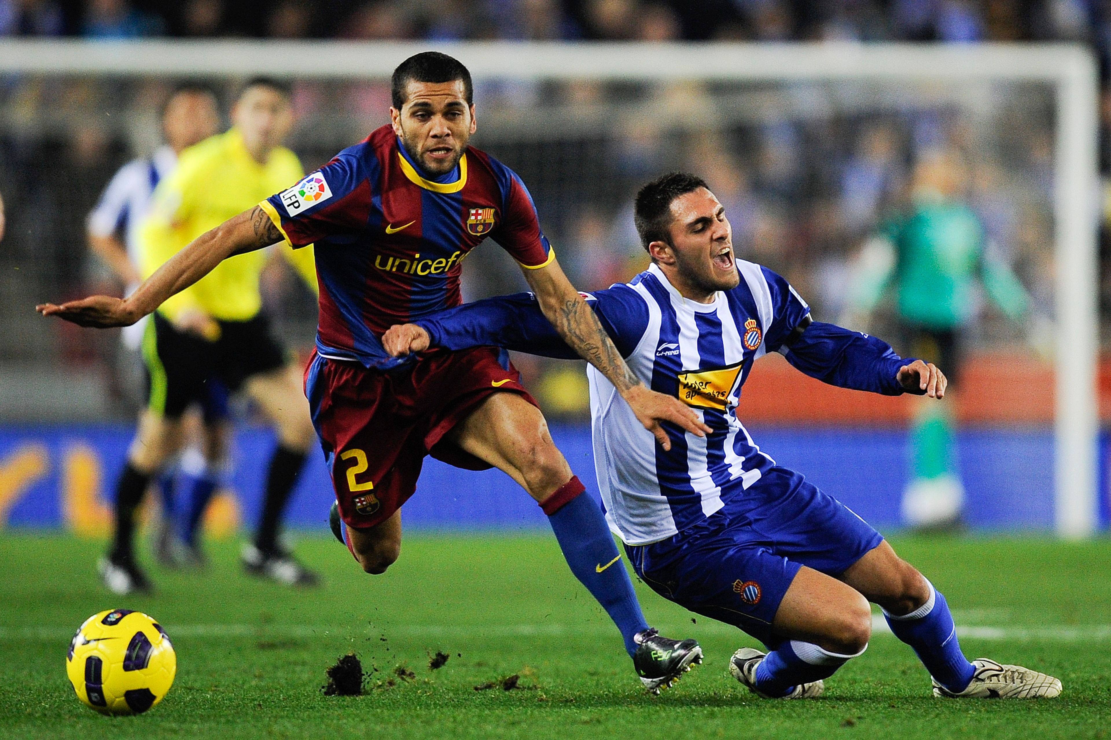 BARCELONA, SPAIN - DECEMBER 18: Dani Alves of Barcelona (L) and Victor Ruiz of Espanyol duel for a ball during the La Liga match between Espanyol and Barcelona at Cornella - El Prat stadium on December 18, 2010 in Barcelona, Spain. Barcelona won the match