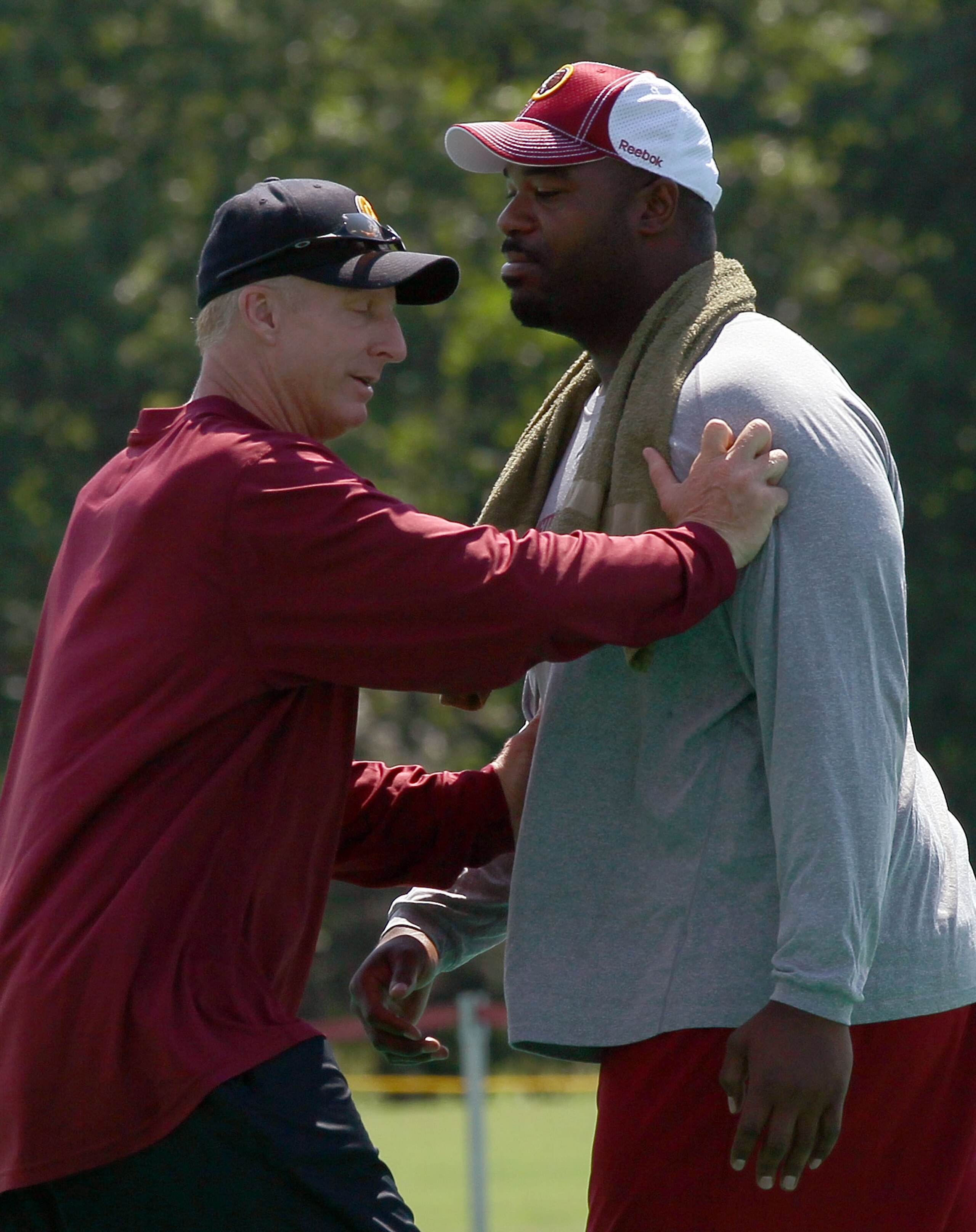 ASHBURN, VA - JULY 30:  Defensive lineman Albert Haynesworth #92 of the Washington Redskins works out with defensive coordinator Jim Haslett (L) following practice on the second day of training camp July 30, 2010 in Ashburn, Virginia. Haynesworth failed a