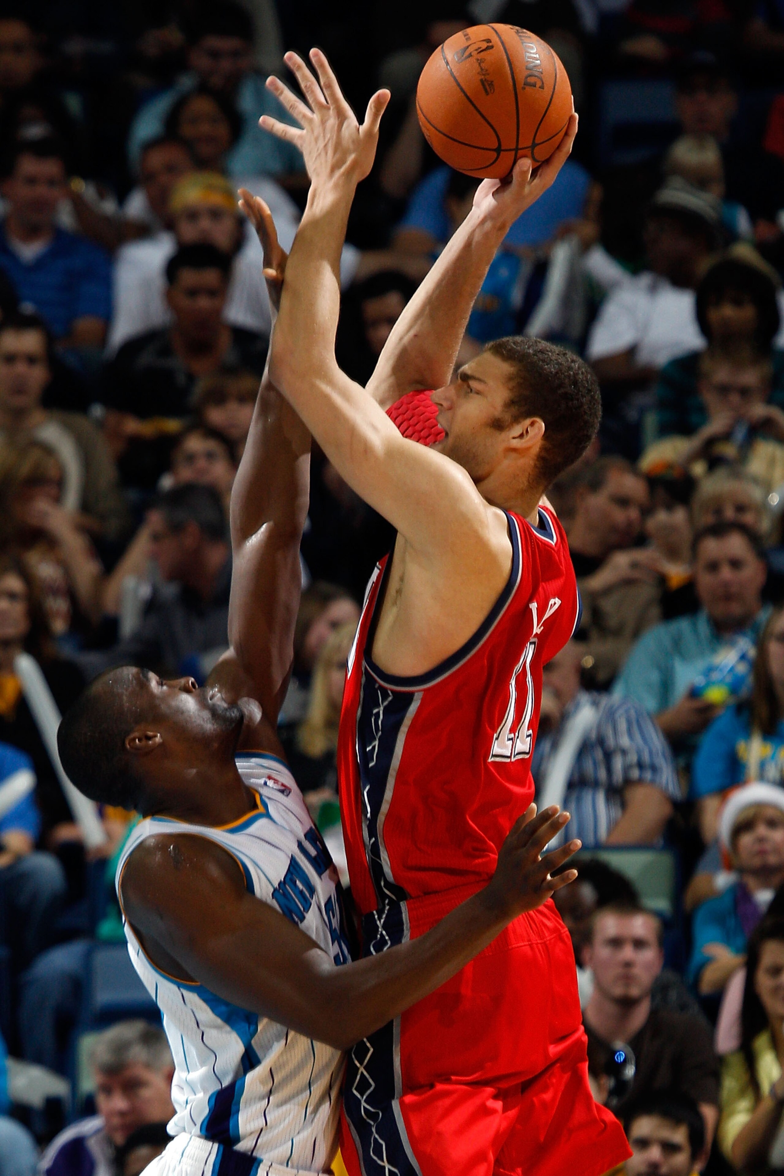 NEW ORLEANS, LA - DECEMBER 22:  Brook Lopez #11 of the New Jersey Nets shoots the ball over Emeka Okafor #50 of the New Orleans Hornets at the New Orleans Arena on December 22, 2010 in New Orleans, Louisiana.    The Hornets defeated the Nets 105-91.   NOT