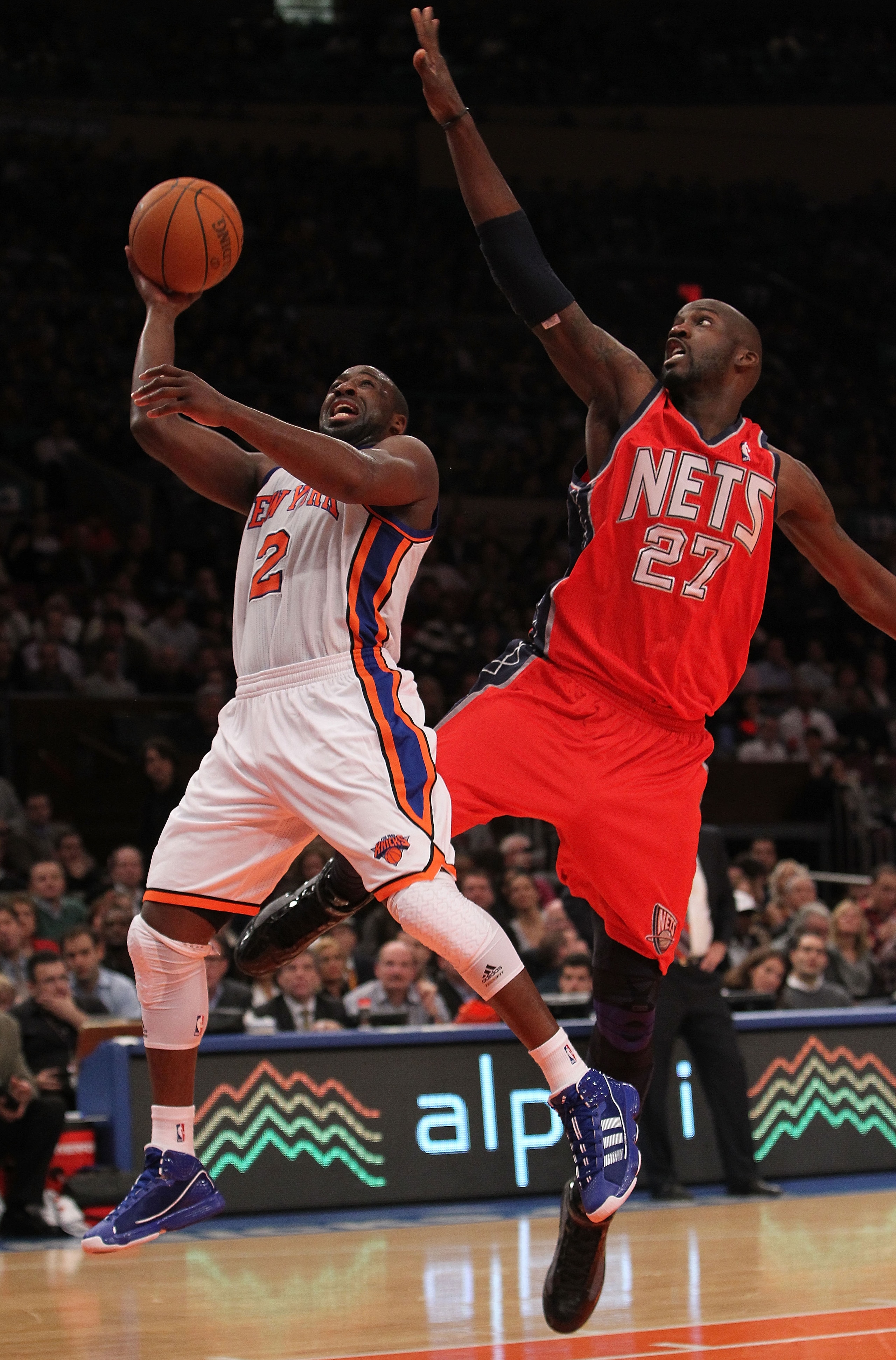 NEW YORK, NY - NOVEMBER 30:  Raymond Felton #2 of the New York Knicks shoots the ball under the block of Johan Petro #27 of the New Jersey Nets on November 30, 2010 at Madison Square Garden in New York City. NOTE TO USER: User expressly acknowledges and a