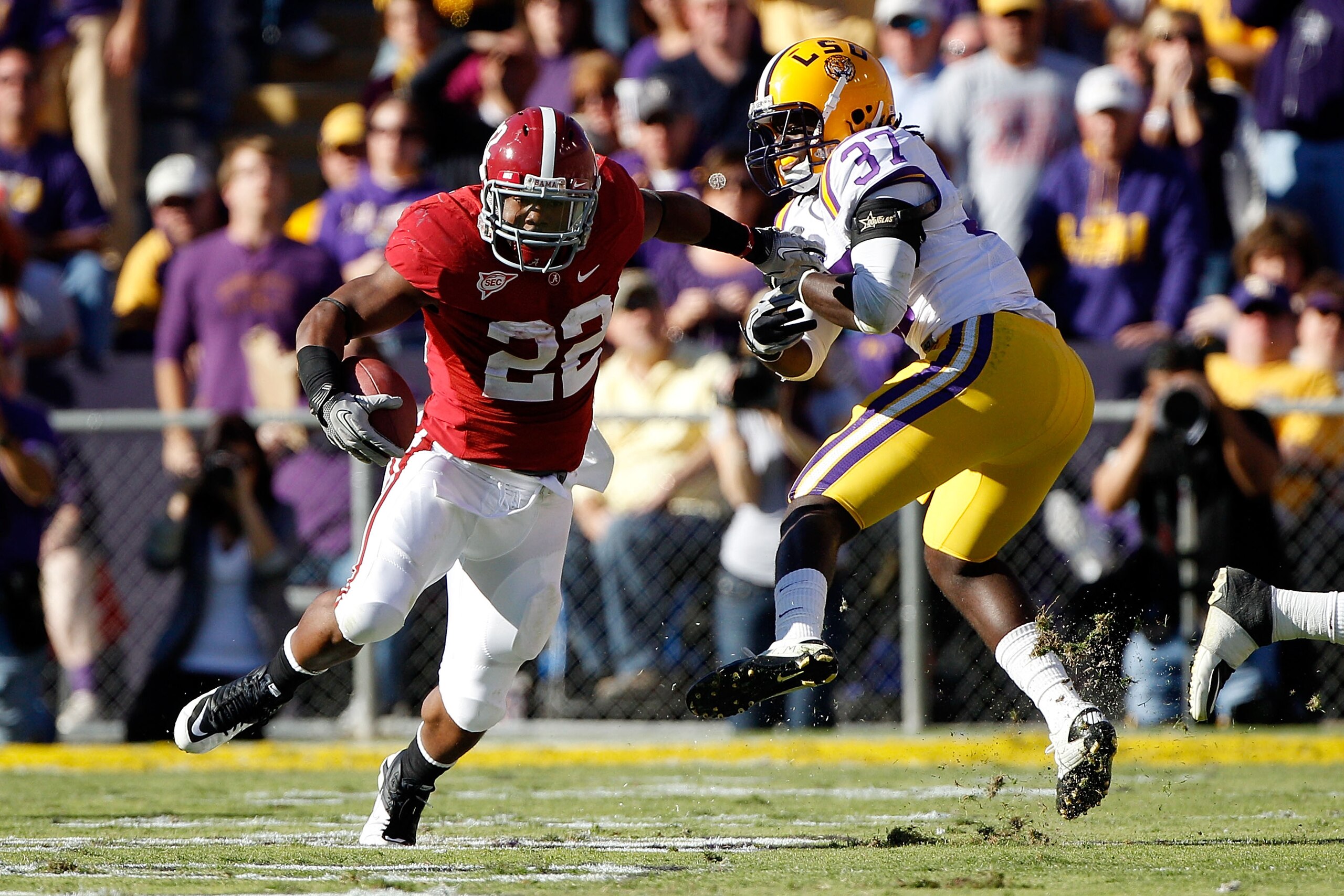 BATON ROUGE, LA - NOVEMBER 06:  Mark Ingram #22 of the Alabama Crimson Tide avoids a tackle by Karnell Hatcher #37 of the Louisiana State University Tigers at Tiger Stadium on November 6, 2010 in Baton Rouge, Louisiana.  (Photo by Chris Graythen/Getty Ima