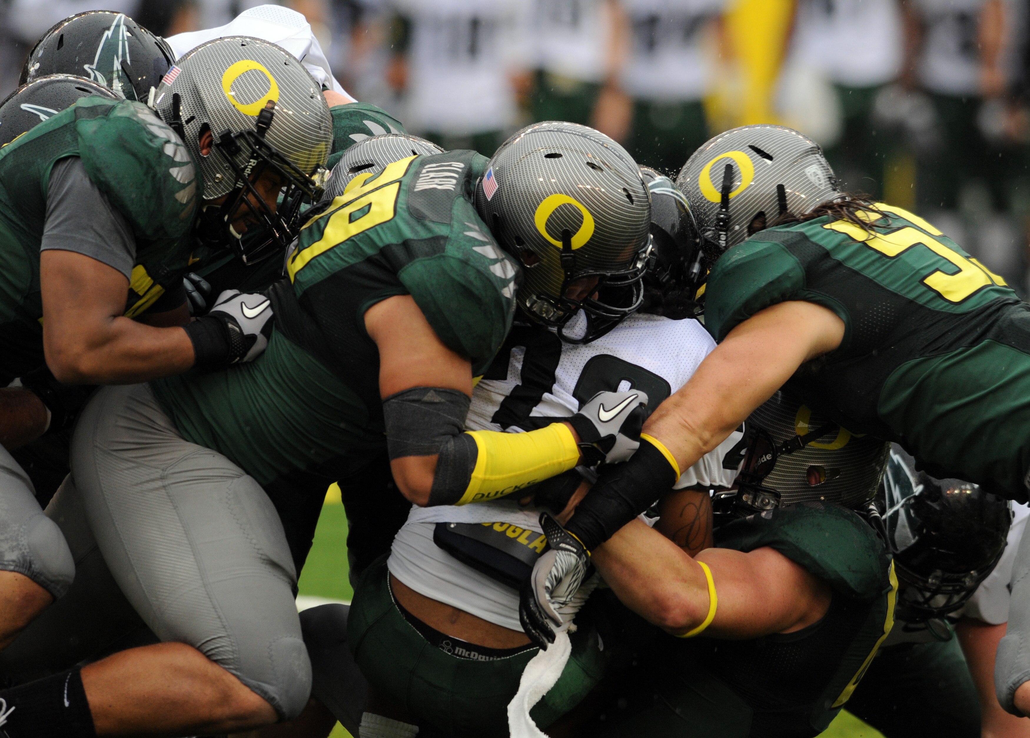 EUGENE, OR - SEPTEMBER 18: Running back Willie Griffin #28 of the Portland State is gang tackled by (L to R) defensive end Kenny Rowe, defensive tackle Zac Clark #99 and linebacker Casey Matthews #55 of the Oregon Ducks in the second quarter of the game a