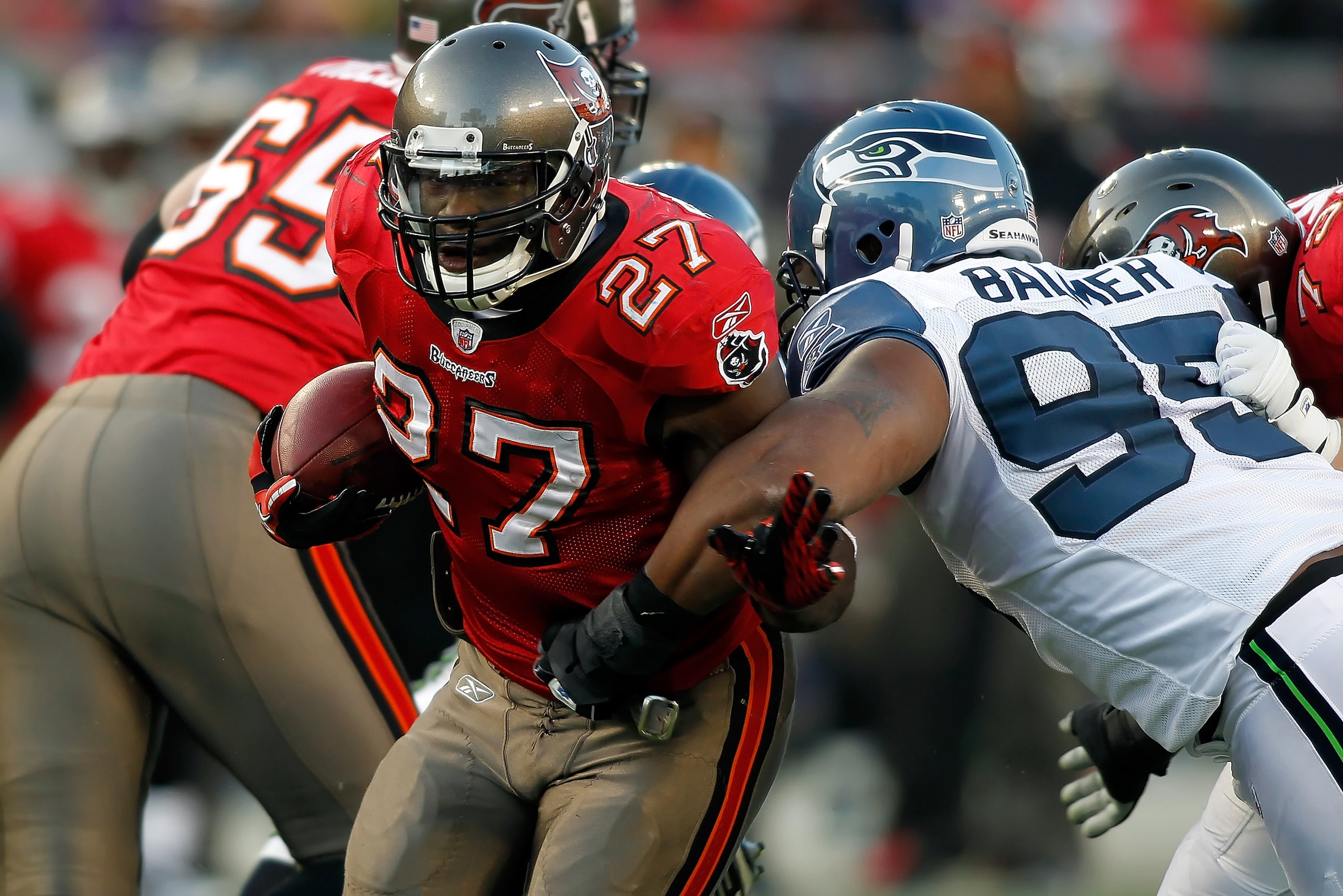 TAMPA, FL - DECEMBER 26: Running back LeGarrette Blount #27 of the Tampa Bay Buccaneers breaks the tackle of defender Kentwan Balmer #95 of the Seattle Seahawks during the game at Raymond James Stadium on December 26, 2010 in Tampa, Florida. (Photo by J.