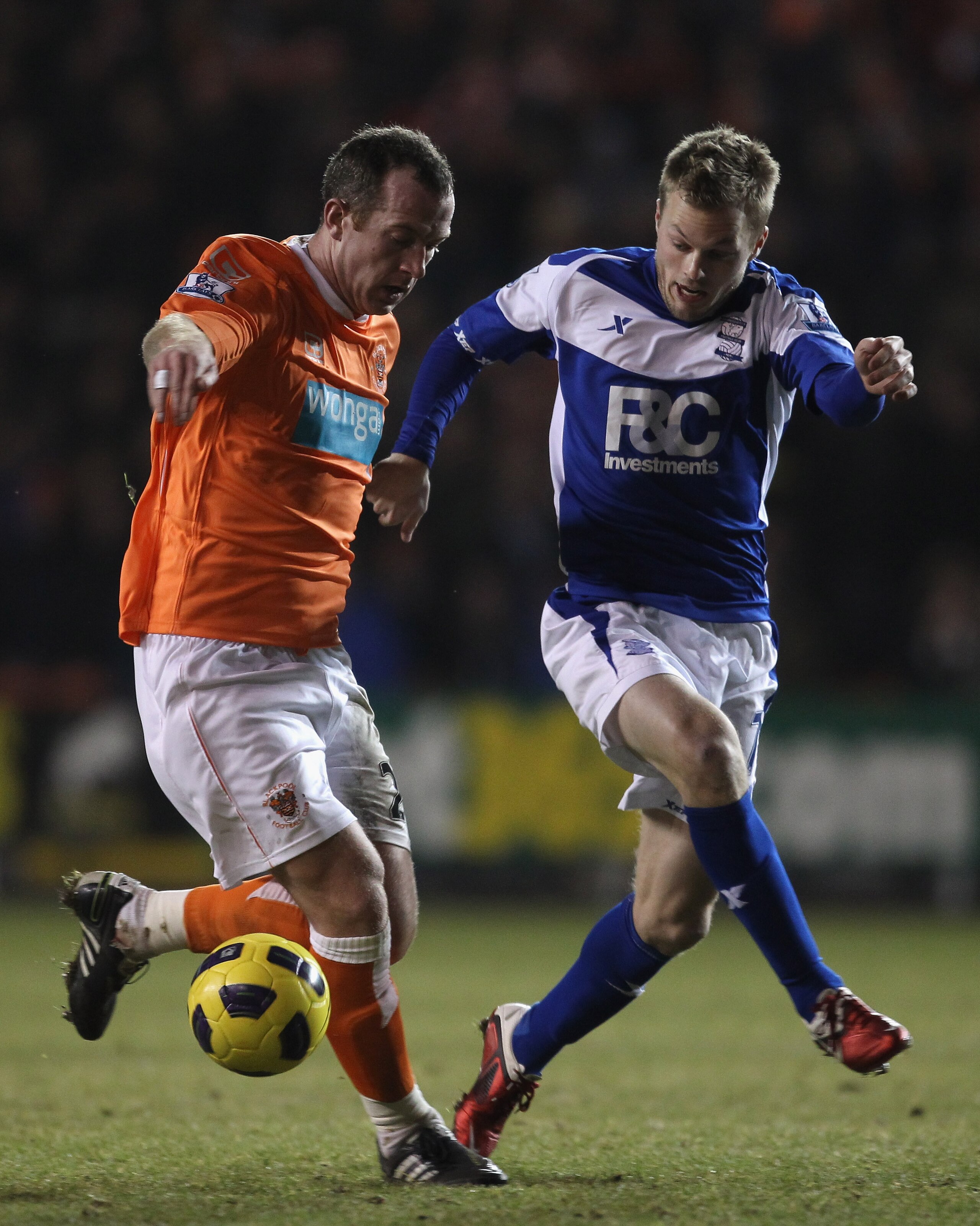 BLACKPOOL, ENGLAND - JANUARY 04:  Charlie Adam of Blackpool holds off a challenge from Sebastian Larsson of Birmingham City during the Barclays Premier League match between Blackpool and Birmingham City at Bloomfield Road on January 4, 2011 in Blackpool,