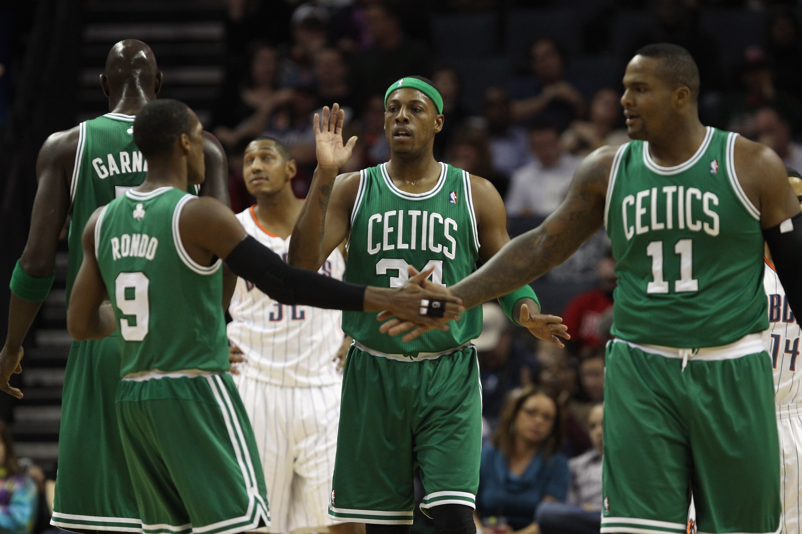 CHARLOTTE, NC - DECEMBER 11:  Teammates Paul Pierce #34 Rajon Rondo #9 and Glen Davis #11 of the Boston Celtics celebrate after a basket against the Charlotte Bobcats during their game at Time Warner Cable Arena on December 11, 2010 in Charlotte, North Ca