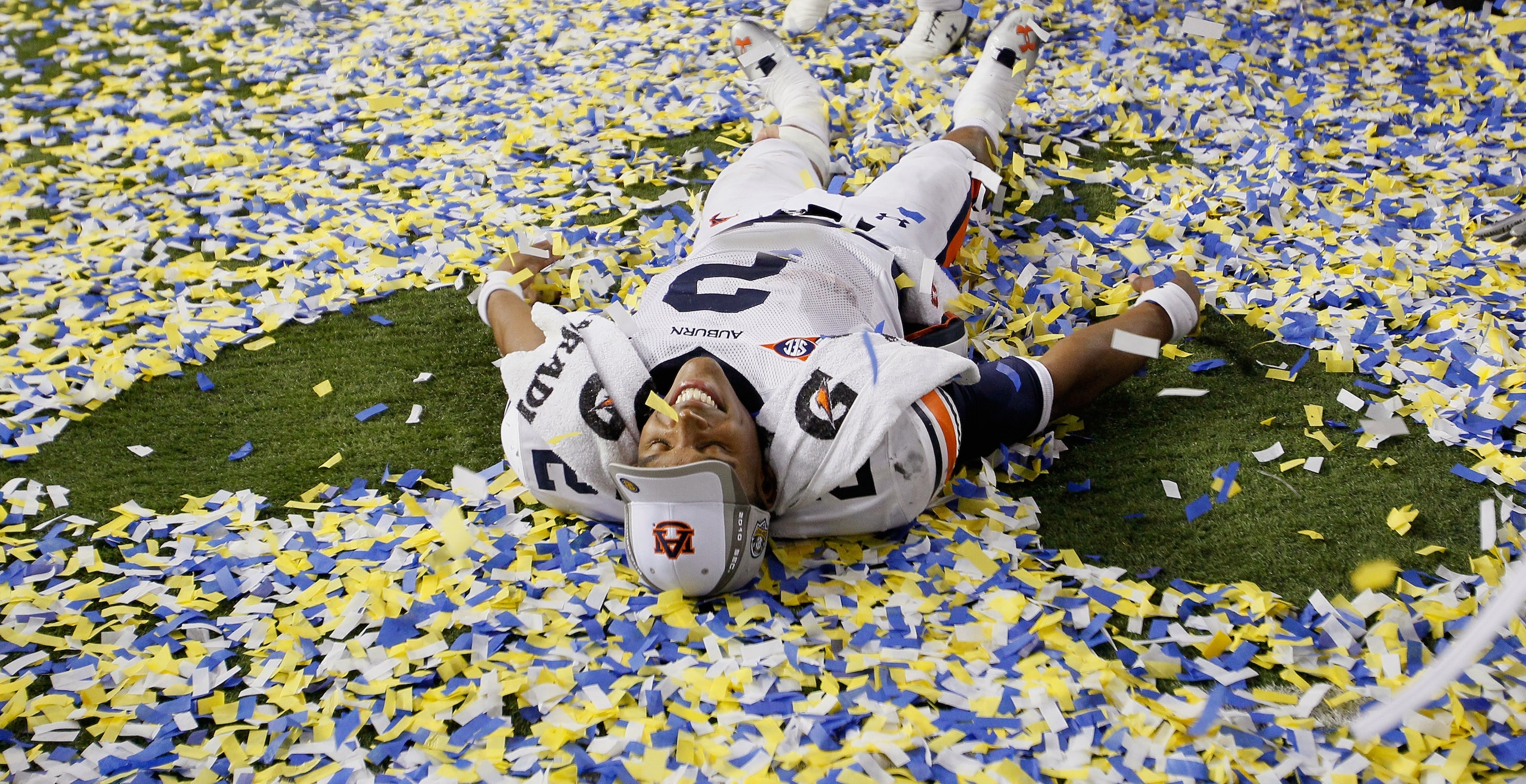 ATLANTA, GA - DECEMBER 04:  Quarterback Cam Newton #2 of the Auburn Tigers makes a 'snow angel' in the confetti as he celebrates after their 56-17 win over the South Carolina Gamecocks during the 2010 SEC Championship at Georgia Dome on December 4, 2010 i