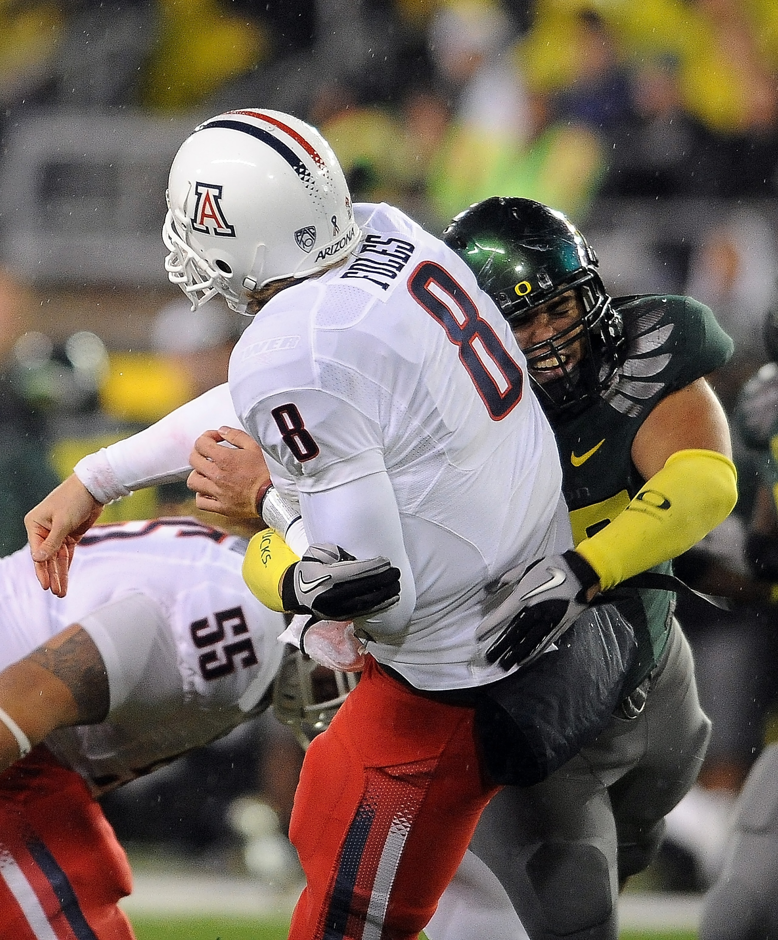 EUGENE, OR - NOVEMBER 26: Quarterback Nick Foles #8 of the Arizona Wildcats is hit by defensive tackle Zac Clark #99 of the Oregon Ducks in the third quarter of the game at Autzen Stadium on November 26, 2010 in Eugene, Oregon. The Ducks won the game 48-2