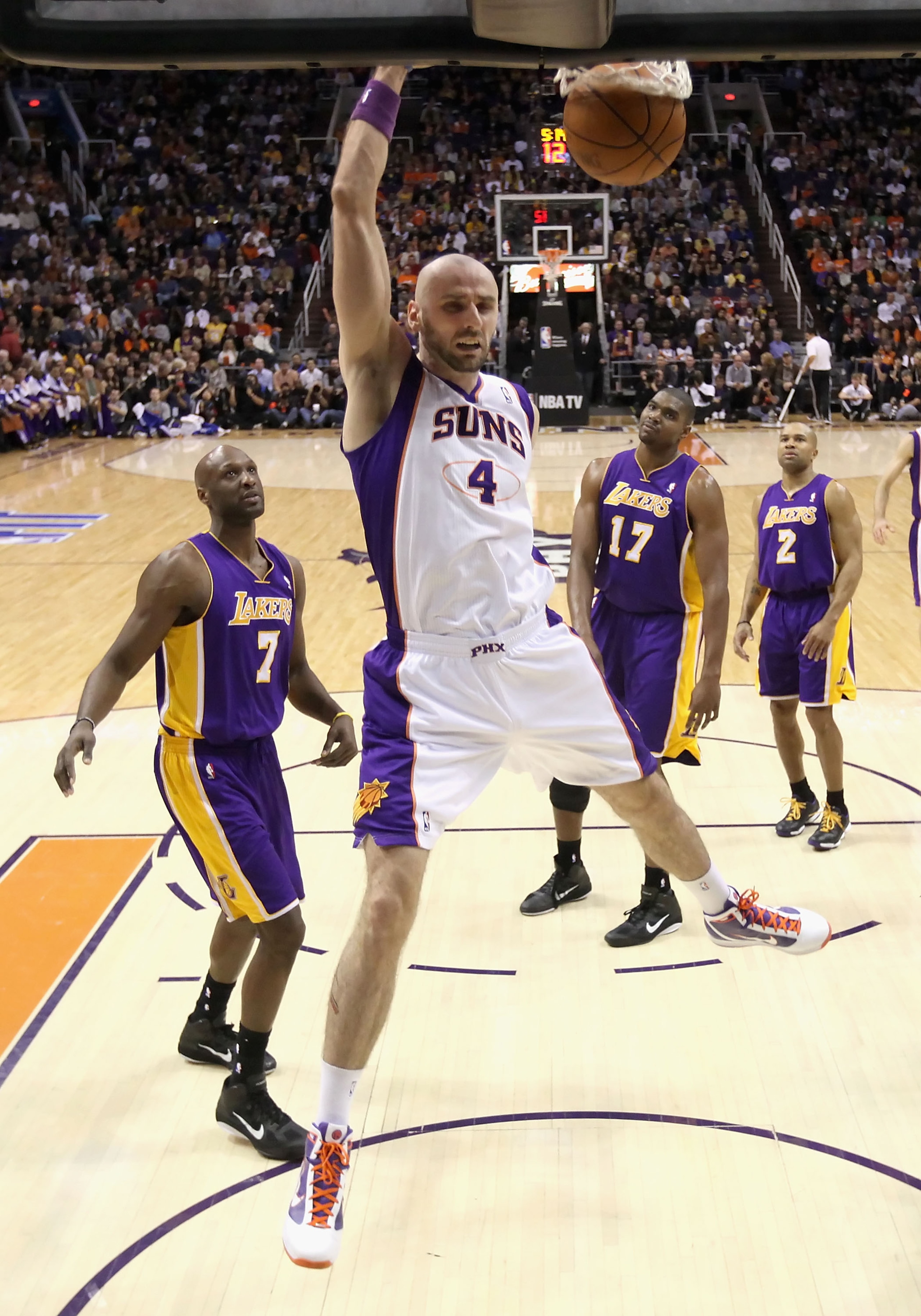 PHOENIX - JANUARY 05: Marcin Gortat #4 of the Phoenix Suns slam dunks the ball past Lamar Odom #7 of the Los Angeles Lakers during the NBA game at US Airways Center on January 5, 2011 in Phoenix, Arizona. The Lakers defeated the Suns 99-95. NOTE TO USER: