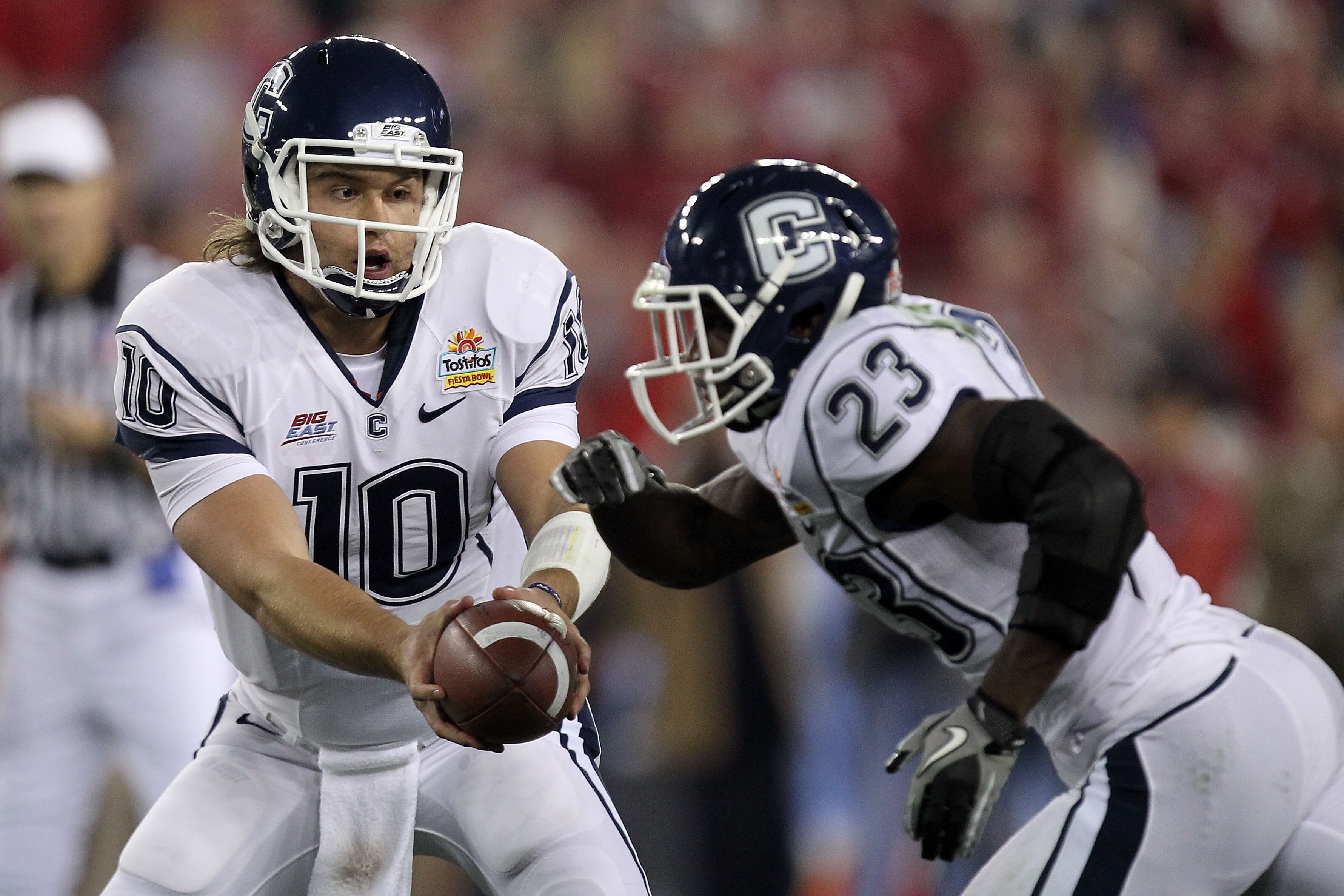 GLENDALE, AZ - JANUARY 01:  Zach Frazer #10 of the Connecticut Huskies  hands the ball off to Jordan Todman #23 against the Oklahoma Sooners during the Tostitos Fiesta Bowl at the Universtity of Phoenix Stadium on January 1, 2011 in Glendale, Arizona.  (P