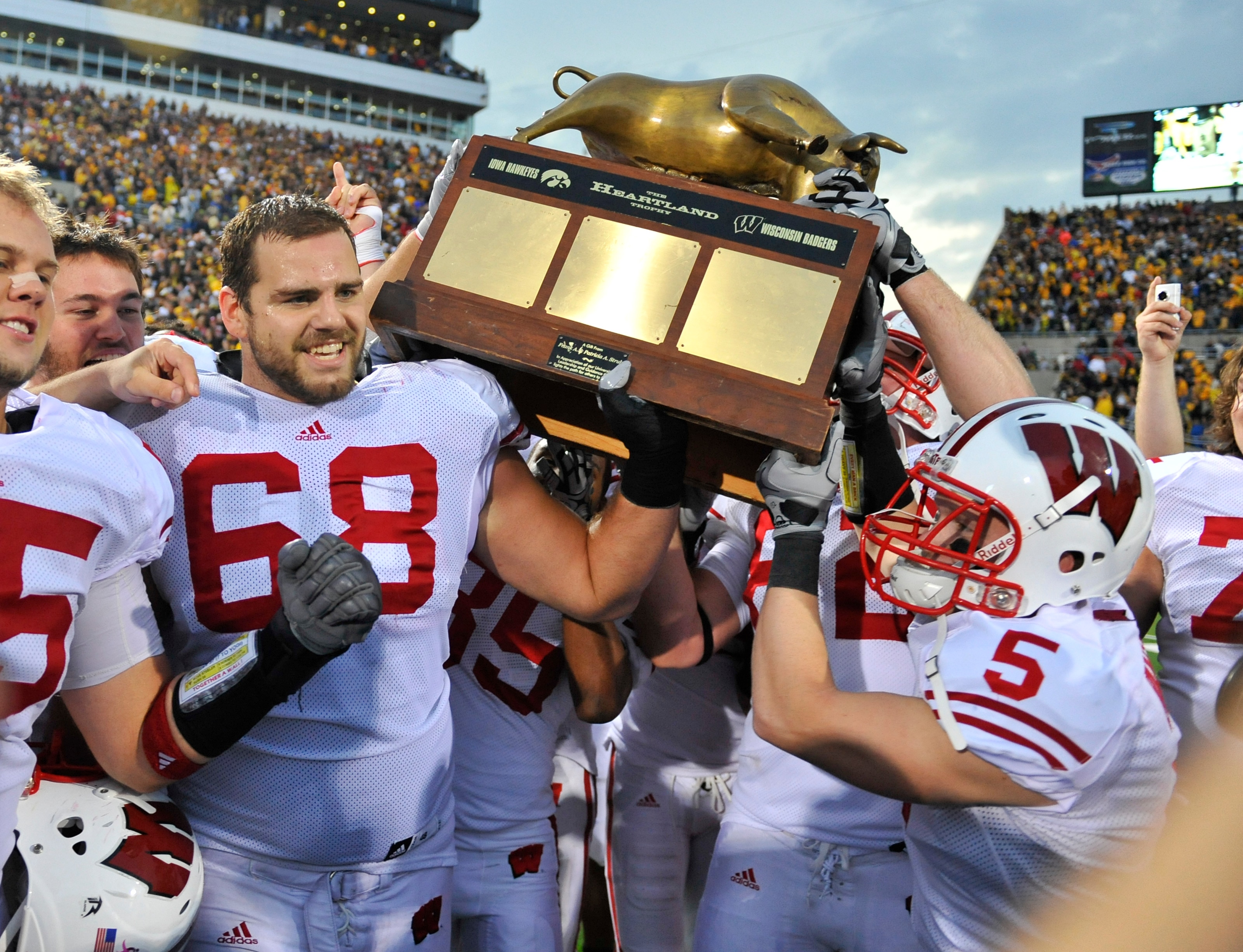 IOWA CITY, IA - OCTOBER 23: Offensive lineman Gabe Carimi #68 for the Wisconsin Badger holds the Heartland Trophy with his teammates as they celebrate their victory of the University of Iowa Hawkeyes at Kinnick Stadium on October 23, 2010 in Iowa City, Io