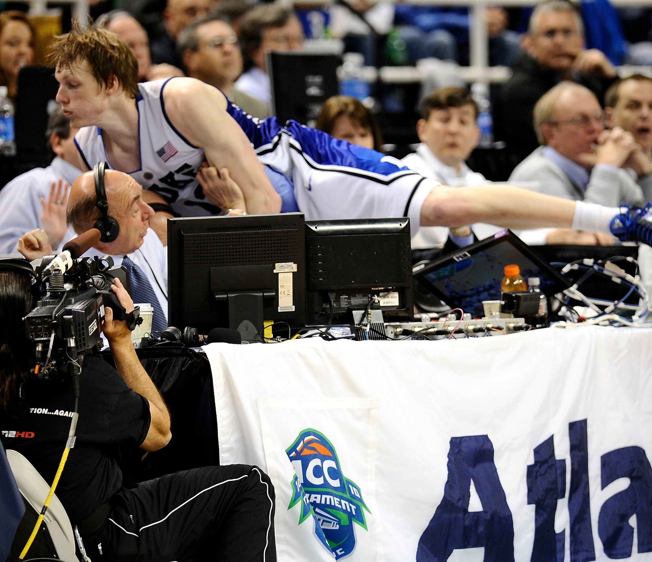 GREENSBORO, NC - MARCH 14:  Kyle Singler #12 of the Duke Blue Devils jumps into ESPN commentator Dick Vitale during game against the Georgia Tech Yellow Jackets in the championship game of the 2010 ACC Men's Basketball Tournament at the Greensboro Coliseu