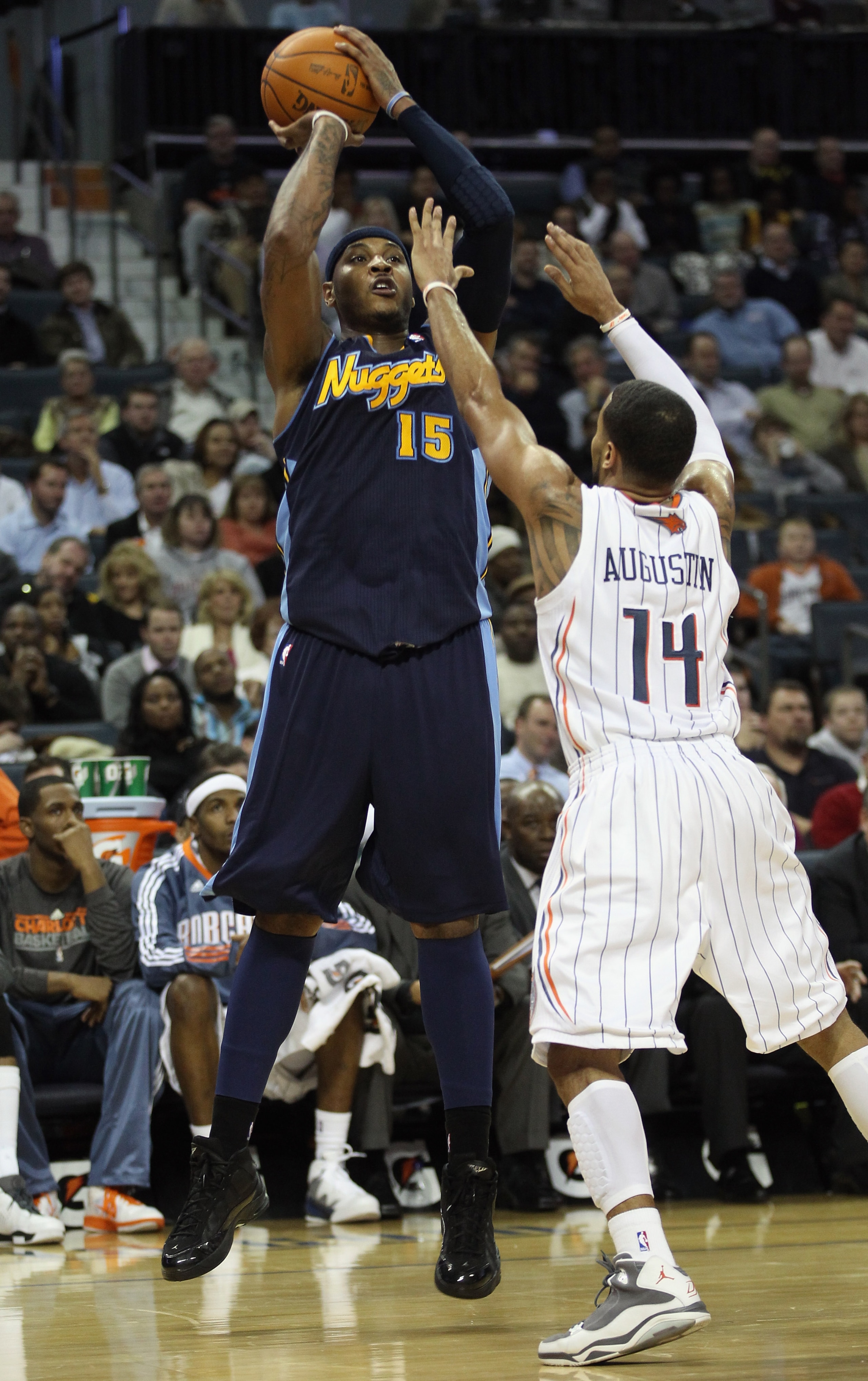 CHARLOTTE, NC - DECEMBER 07: Carmelo Anthony #15 of the Denver Nuggets shoots over D.J. Augustin #14 of the Charlotte Bobcats during their game at Time Warner Cable Arena on December 7, 2010 in Charlotte, North Carolina. NOTE TO USER: User expressly ack CHARLOTTE, NC - DECEMBER 07: Carmelo Anthony #15 of the Denver Nuggets shoots over D.J. Augustin #14 of the Charlotte Bobcats during their game at Time Warner Cable Arena on December 7, 2010 in Charlotte, North Carolina. NOTE TO USER: User expressly ack