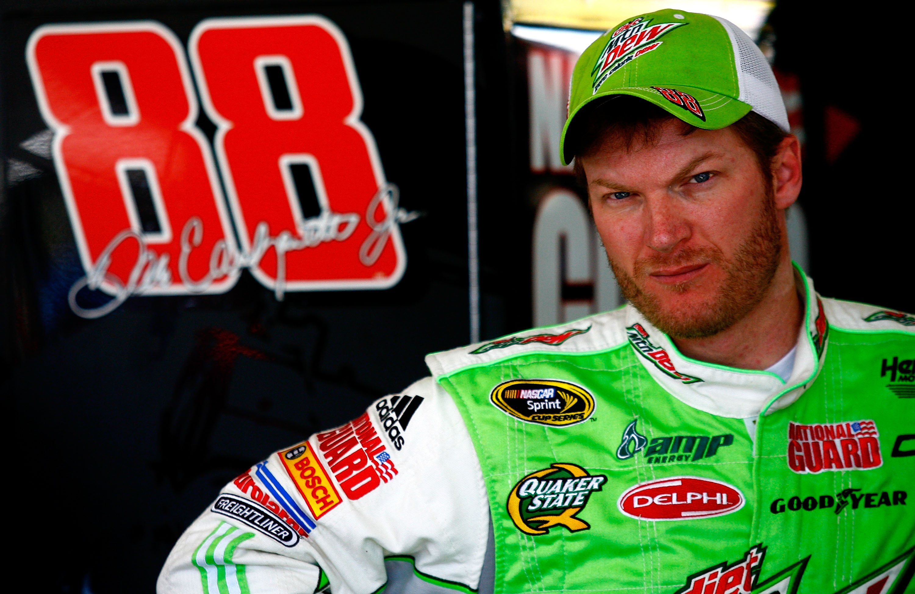 AVONDALE, AZ - NOVEMBER 13:  Dale Earnhardt Jr., driver of the #88 Diet Mountain Dew Chevrolet, stands in the garage area during practice for the NASCAR Sprint Cup Series Kobalt Tools 500 at Phoenix International Raceway on November 13, 2010 in Avondale,