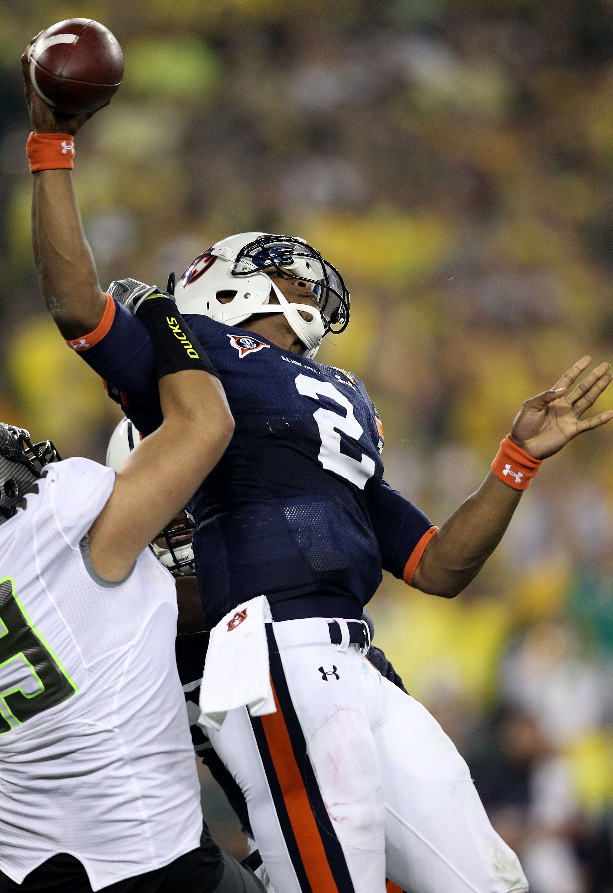 GLENDALE, AZ - JANUARY 10:  Quarterback Cameron Newton #2 of the Auburn Tigers is sacked by Zac Clark #99 of the Oregon Ducks in the first quarter during the Tostitos BCS National Championship Game at University of Phoenix Stadium on January 10, 2011 in G