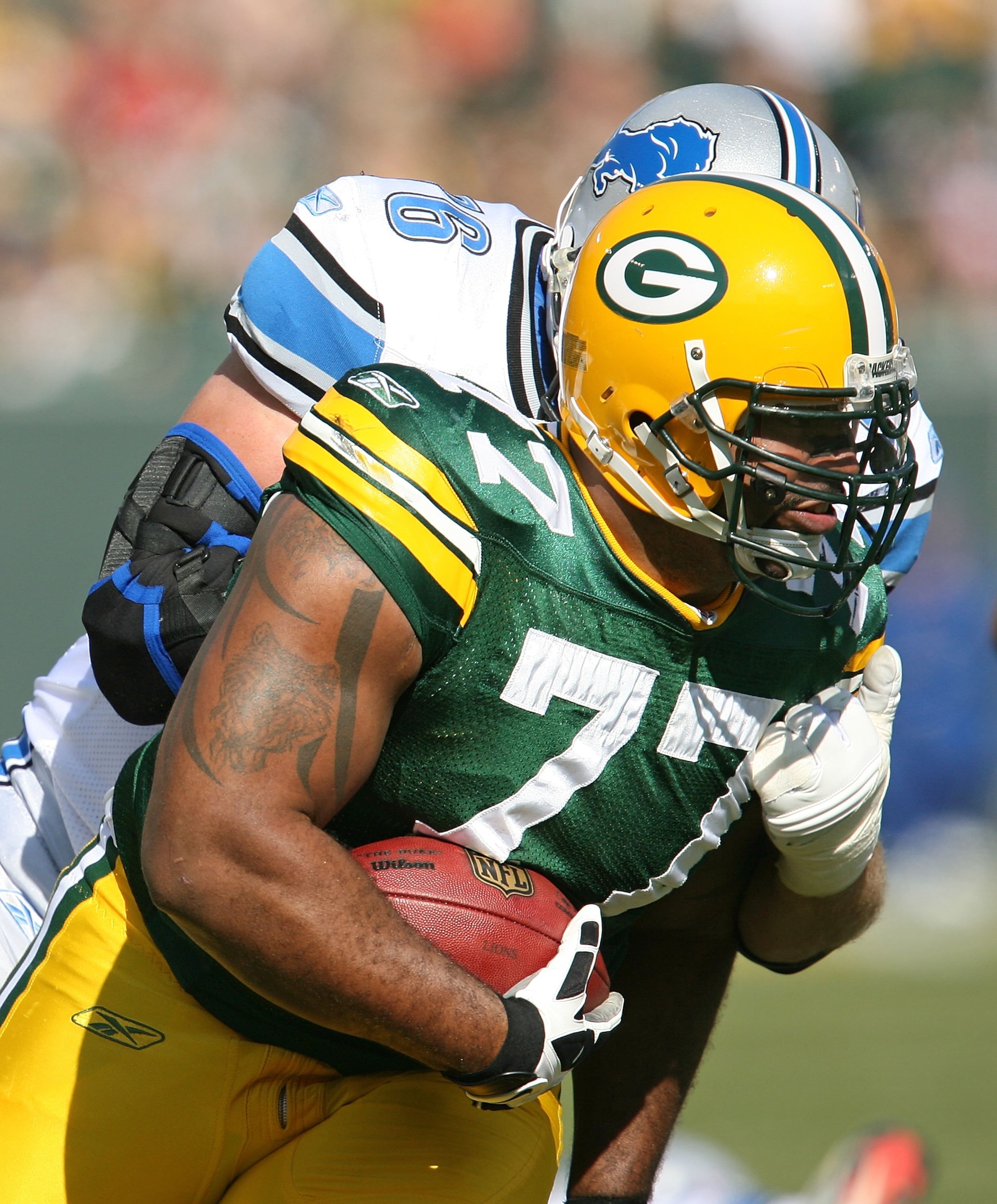 GREEN BAY, WI - OCTOBER 18: Cullen Jenkins #77 of the Green Bay Packers is brought down after intercepting a pass by Jeff Backus #76 of Detroit Lions at Lambeau Field on October 18, 2009 in Green Bay, Wisconsin. The Packers defeated the Lions 26-0. (Photo
