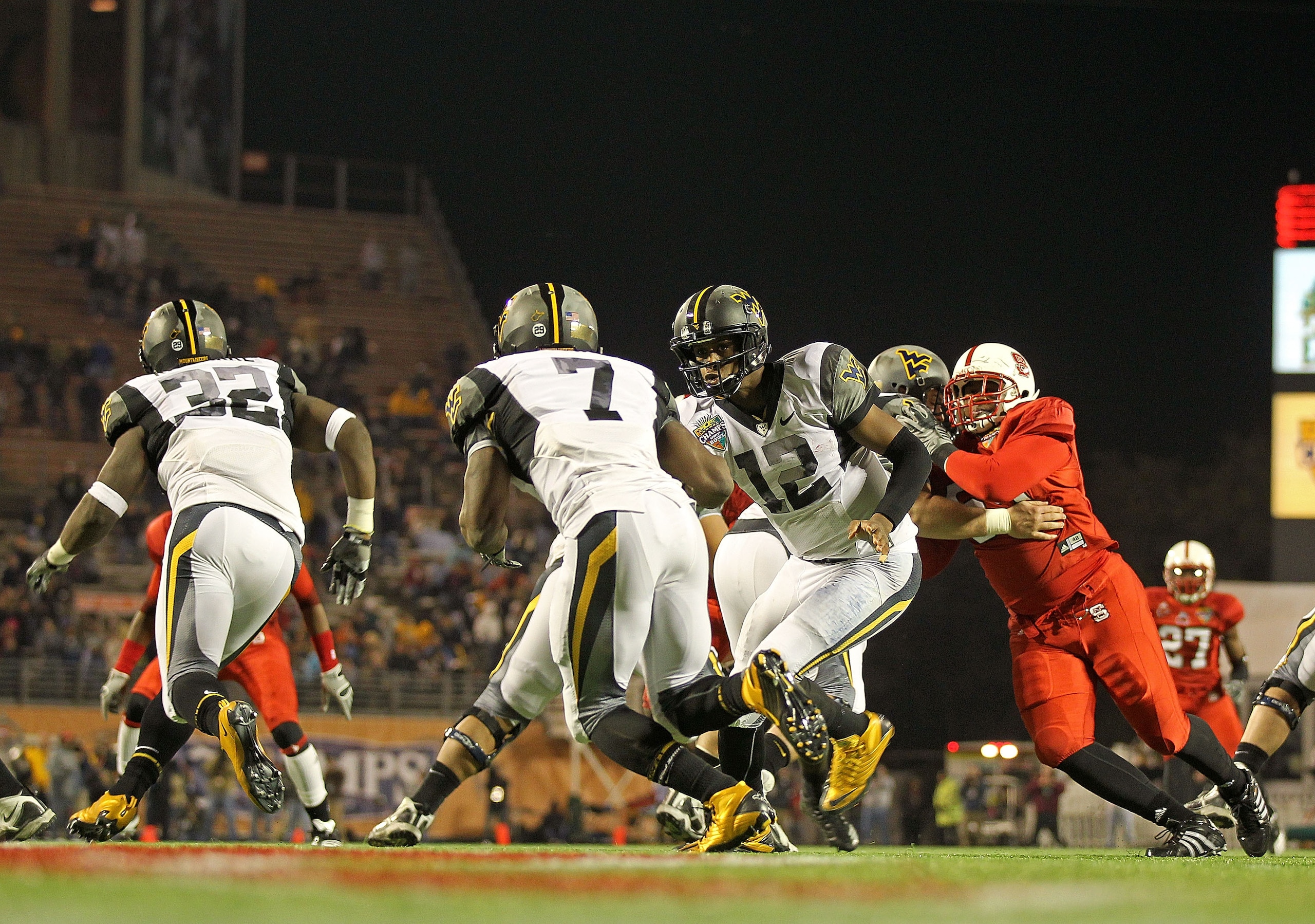 ORLANDO, FL - DECEMBER 28: Geno Smith #12 of the West Virginia Mountineers hands the ball off to Noel Devine #7 during the Champs Sports Bowl against the North Carolina State Wolfpack at Florida Citrus Bowl Stadium on December 28, 2010 in Orlando, Florid ORLANDO, FL - DECEMBER 28: Geno Smith #12 of the West Virginia Mountineers hands the ball off to Noel Devine #7 during the Champs Sports Bowl against the North Carolina State Wolfpack at Florida Citrus Bowl Stadium on December 28, 2010 in Orlando, Florid