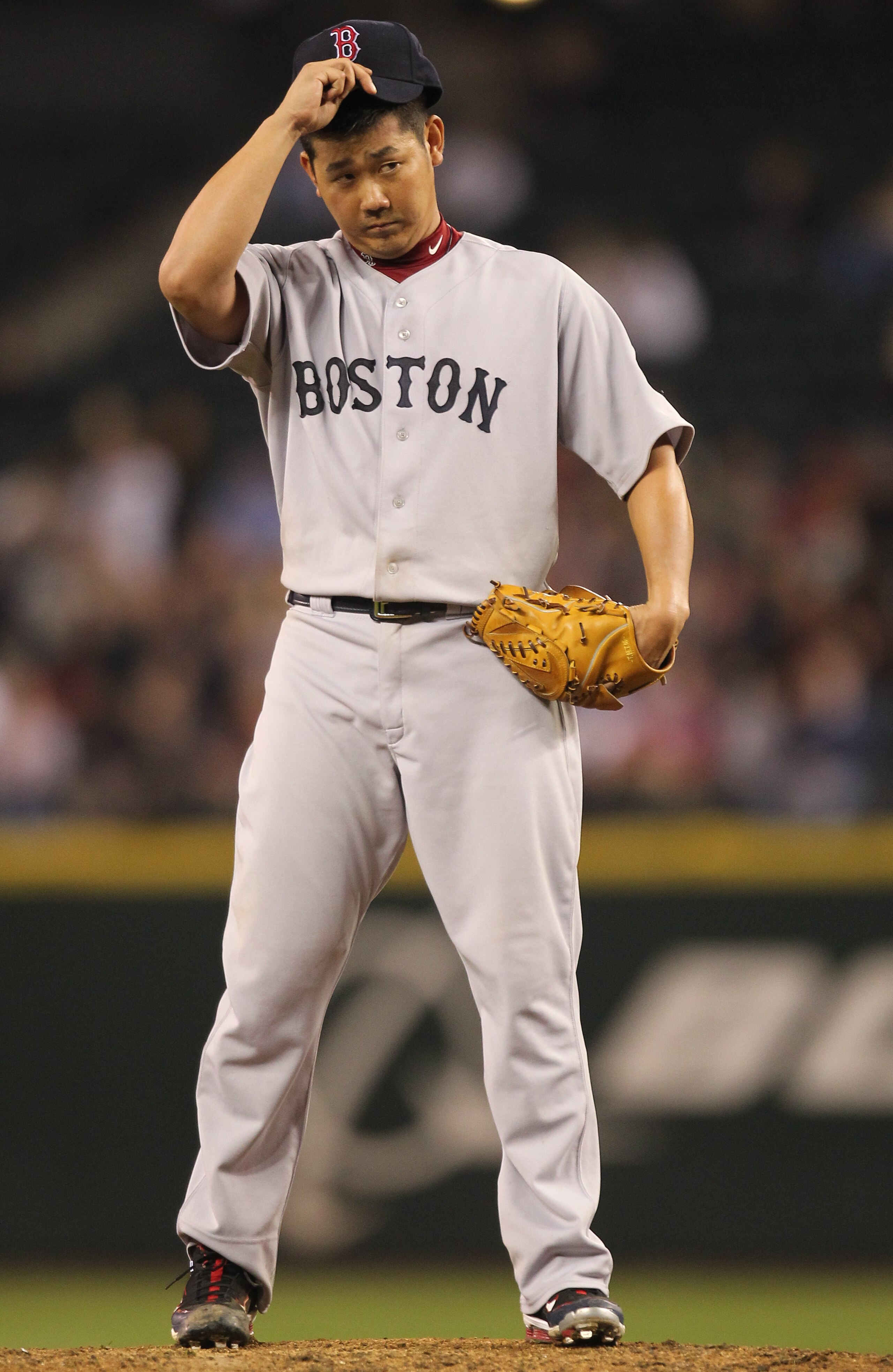 SEATTLE - SEPTEMBER 14:  Starting pitcher Daisuke Matsuzaka #18 of the Boston Red Sox adjusts his cap during the game against the Seattle Mariners at Safeco Field on September 14, 2010 in Seattle, Washington. The Red Sox won 9-6. (Photo by Otto Greule Jr/