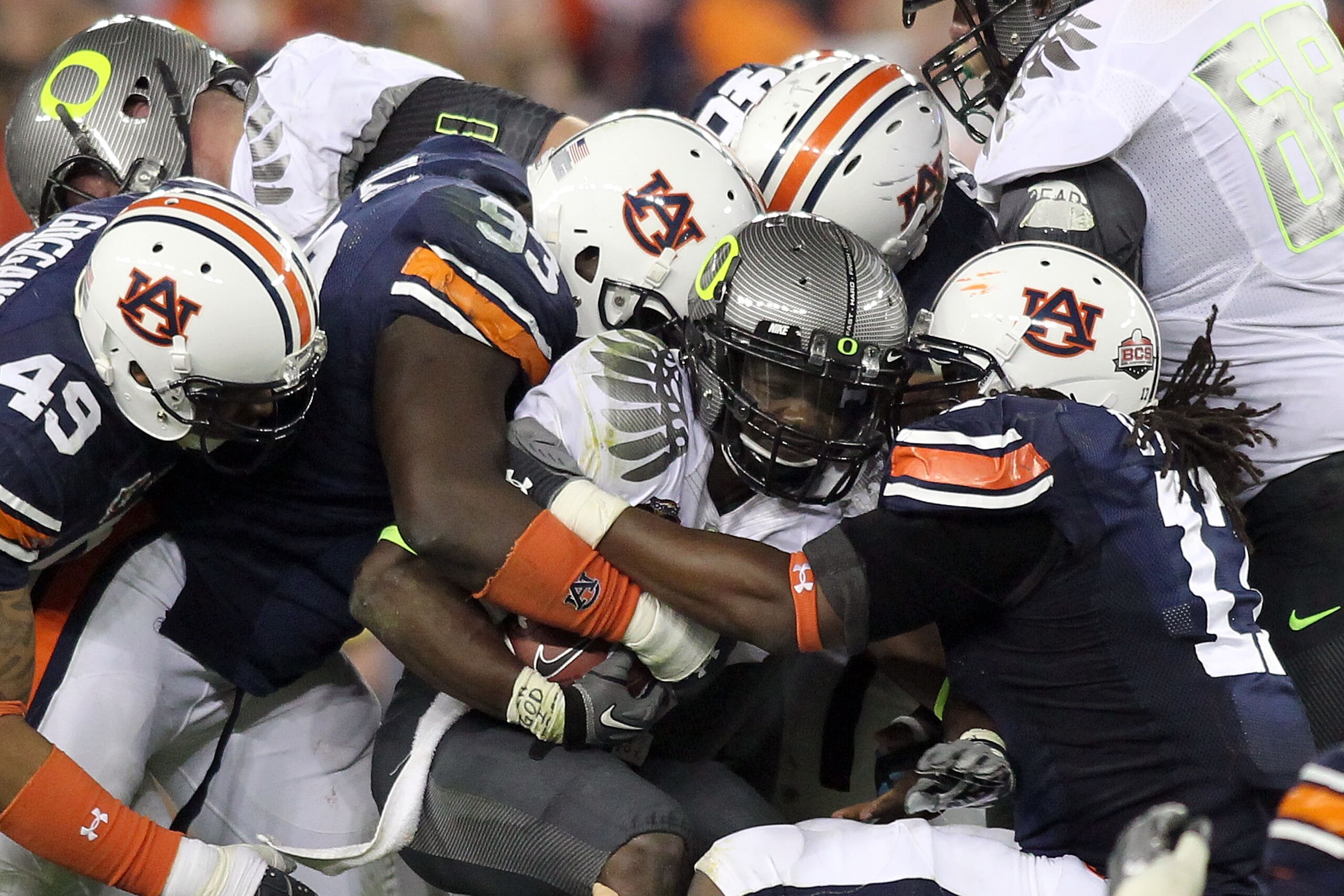 GLENDALE, AZ - JANUARY 10:  Kenjon Barner #24 of the Oregon Ducks runs the ball in the third quarter as he is tackled by the Auburn Tigers defense during the Tostitos BCS National Championship Game at University of Phoenix Stadium on January 10, 2011 in G