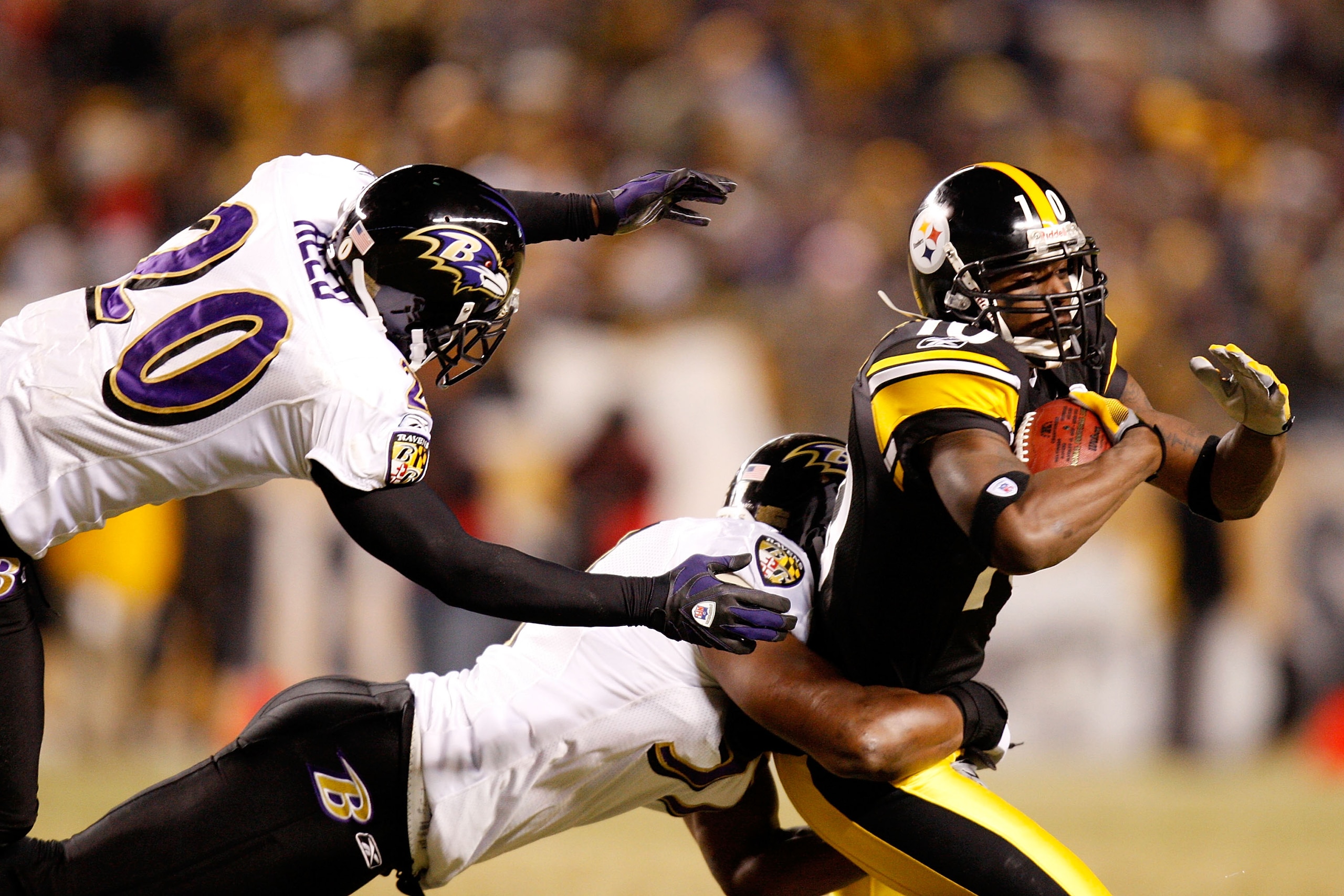 PITTSBURGH - JANUARY 18:  Wide receiver Santonio Holmes #10 of the Pittsburgh Steelers runs the ball against Frank Walker #41 and Ed Reed #20 of the Baltimore Ravens during the AFC championship game on January 18, 2009 at Heinz Field in Pittsburgh, Pennsy