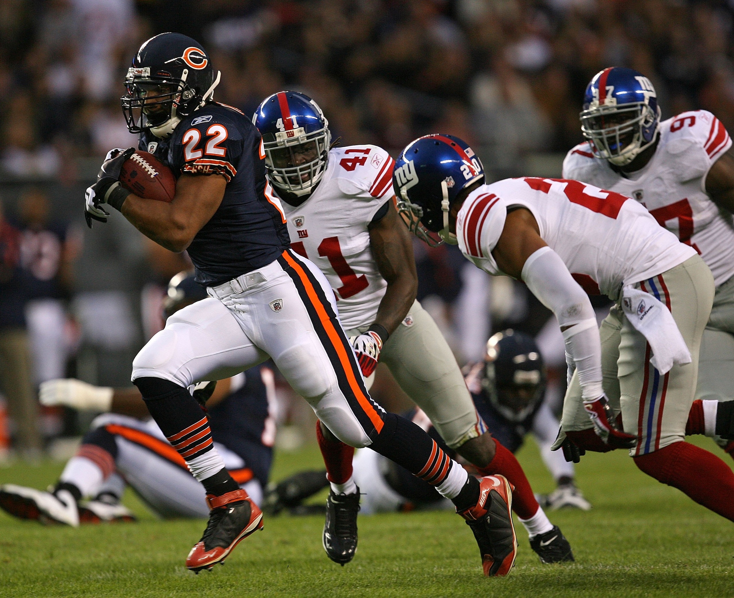 CHICAGO - AUGUST 22: Matt Forte #22 of the Chicago Bears runs for a touchdown past Michael Johnson #20 and C.C. Brown #41 of the New York Giants during a pre-season game on August 22, 2009 at Soldier Field in Chicago, Illinois. The Bears defeated the Gian