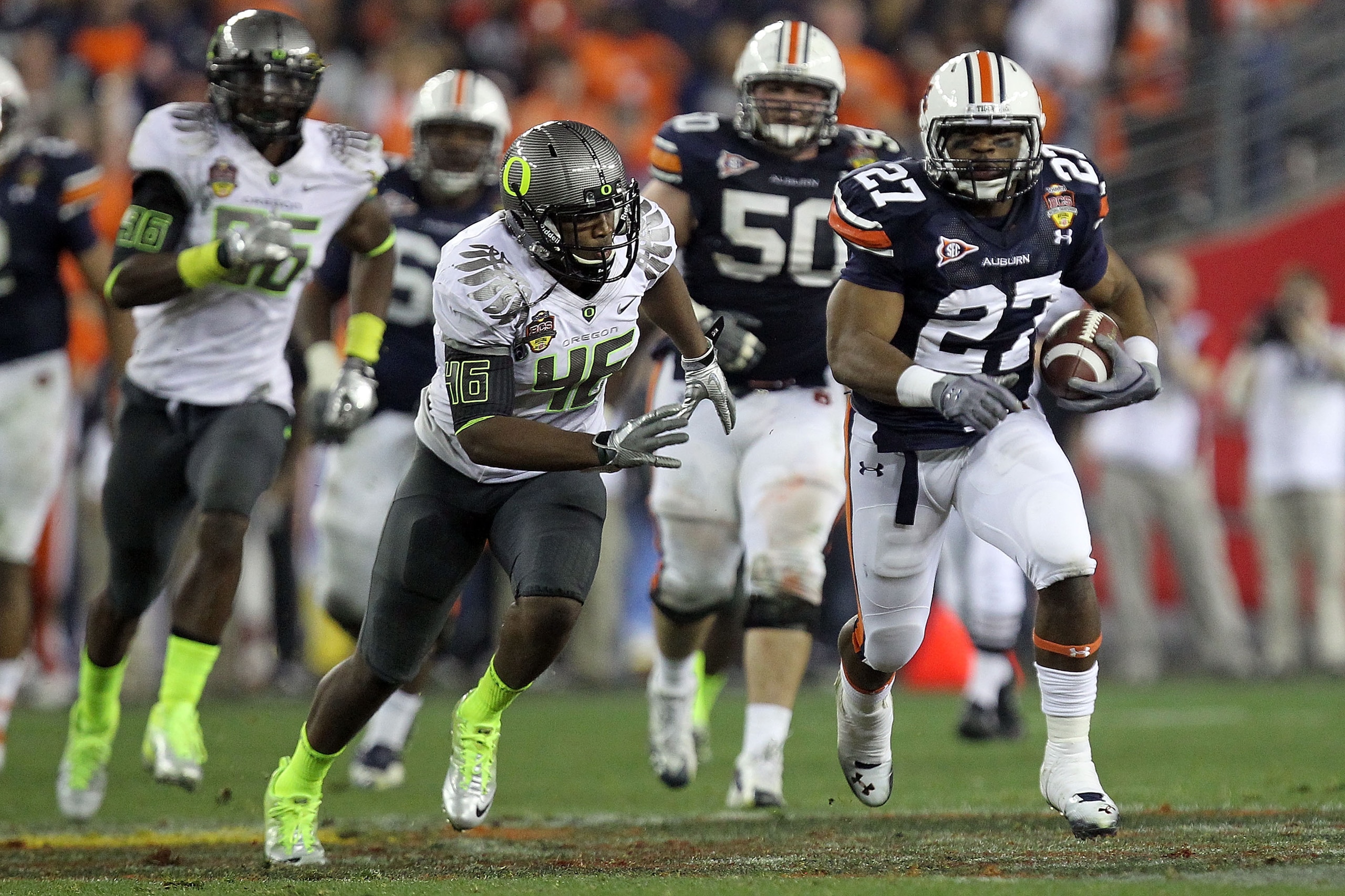 GLENDALE, AZ - JANUARY 10:  Mario Fannin #27 of the Auburn Tigers runs the ball in the second half against Terrell Turner #45 of the Oregon Ducks during the Tostitos BCS National Championship Game at University of Phoenix Stadium on January 10, 2011 in Gl