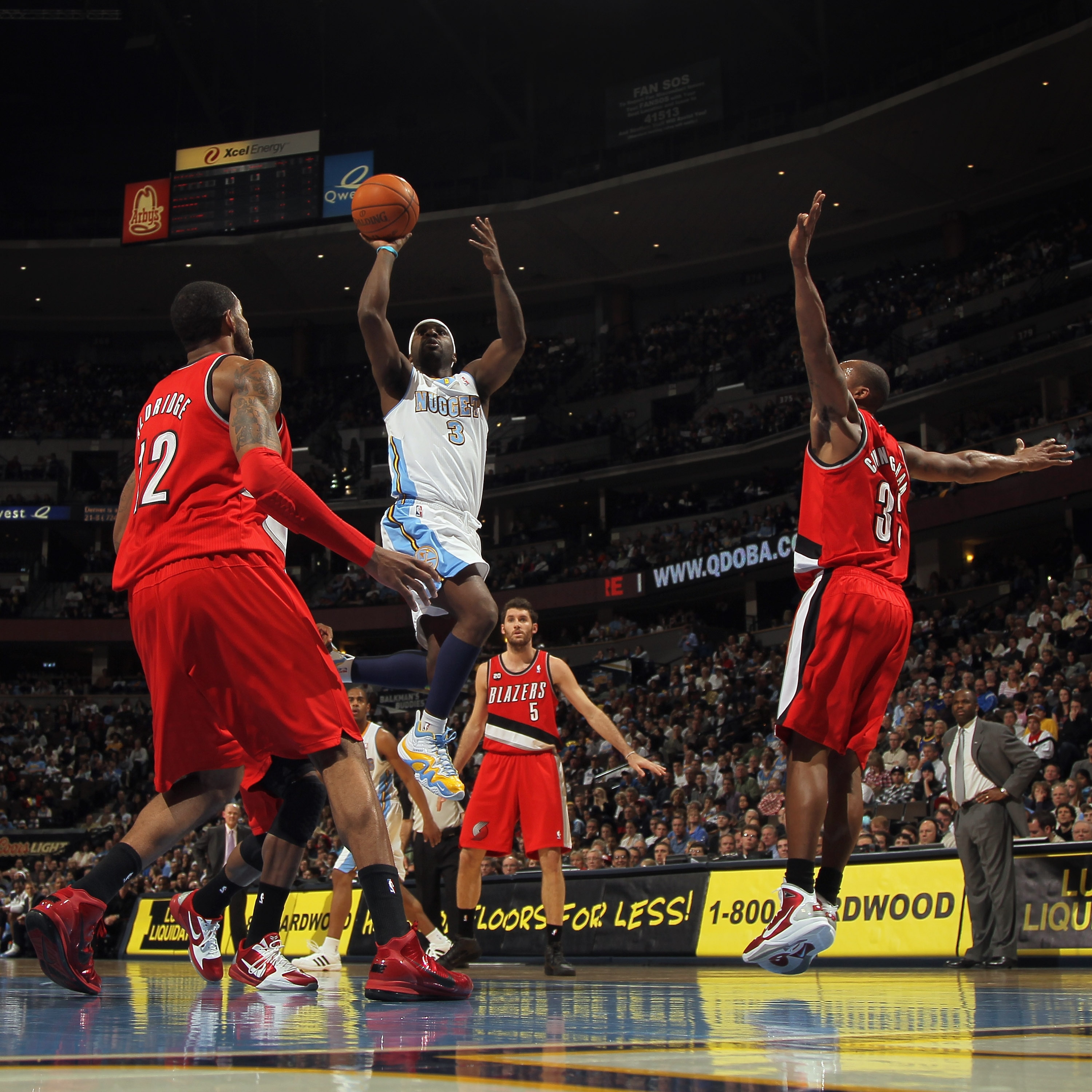DENVER - DECEMBER 28: Ty Lawson #3 of the Denver Nuggets takes a shot between Wesley Matthews #2 and Dante Cunningham #33 of the Portland Trail Blazers at Pepsi Center on December 28, 2010 in Denver, Colorado. The Nuggets defeated the Blazers 95-77. NOTE