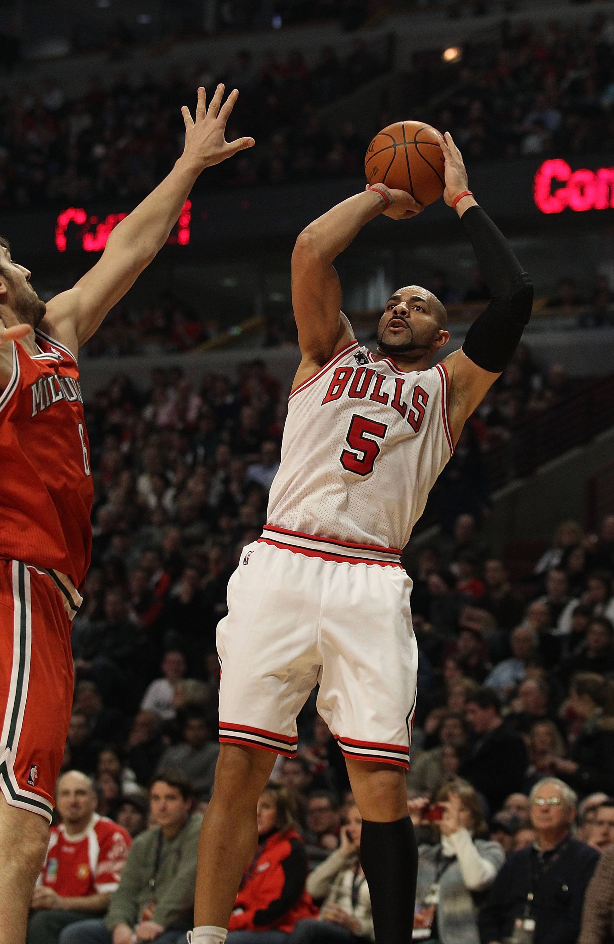 CHICAGO, IL - DECEMBER 28: Carlos Boozer #5 of the Chicago Bulls puts up a shot against Andrew Bogut #6 of the Milwaukee Bucks at the United Center on December 28, 2010 in Chicago, Illinois. The Bulls defeated the Bucks 90-77. NOTE TO USER: User expressly