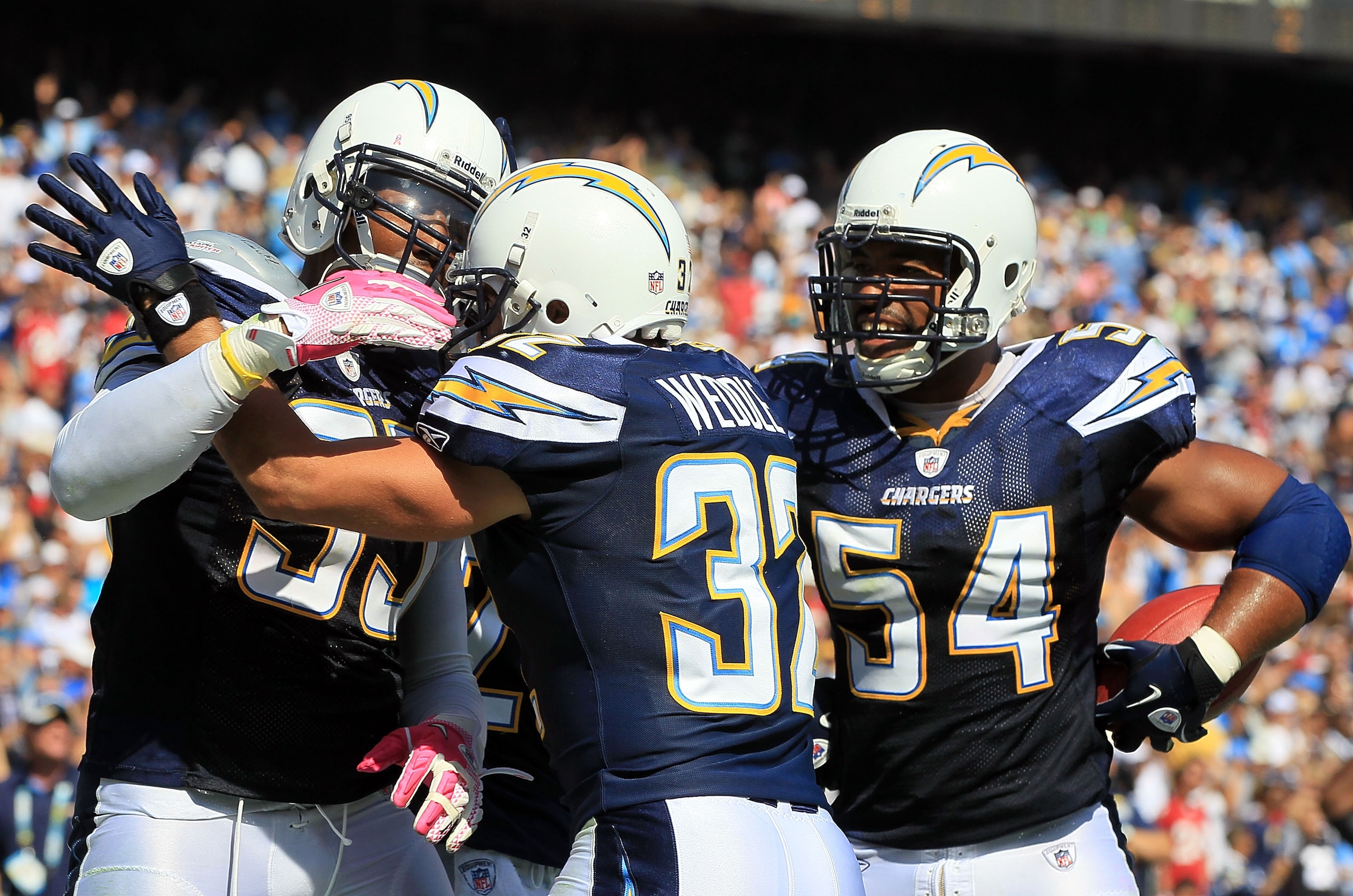 SAN DIEGO - OCTOBER 03:  Eric Weddle #32 and Stephen Cooper #54 of the San Diego Chargers congratulate teammate Shaun Phillips #95 after intercepting a pass for a touchdown against the Arizona Cardinals at Qualcomm Stadium on October 3, 2010 in San Diego,