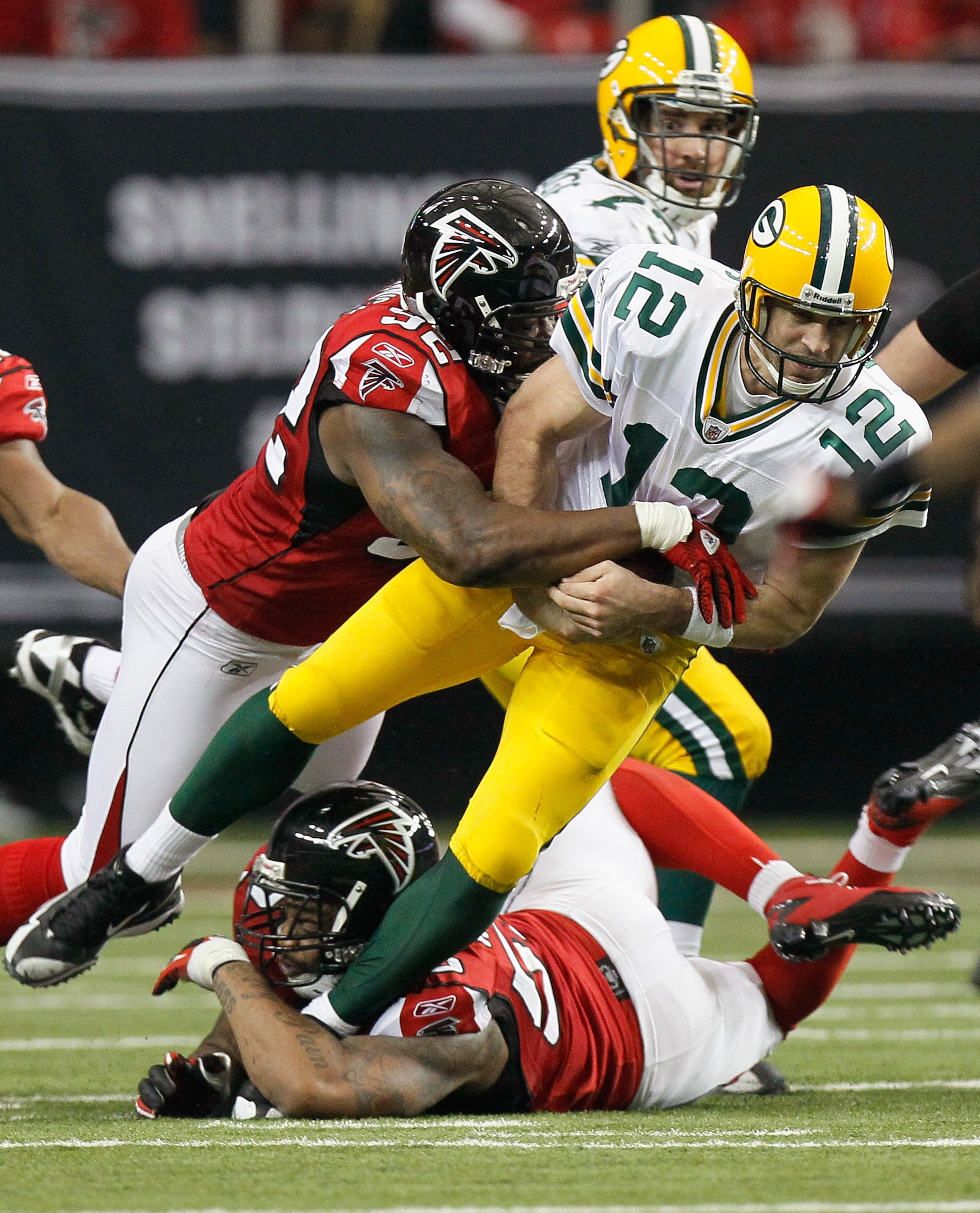 ATLANTA - NOVEMBER 28:  Chauncey Davis #92 and John Abraham #55 of the Atlanta Falcons sack quarterback Aaron Rodgers #12 of the Green Bay Packers at Georgia Dome on November 28, 2010 in Atlanta, Georgia.  (Photo by Kevin C. Cox/Getty Images)