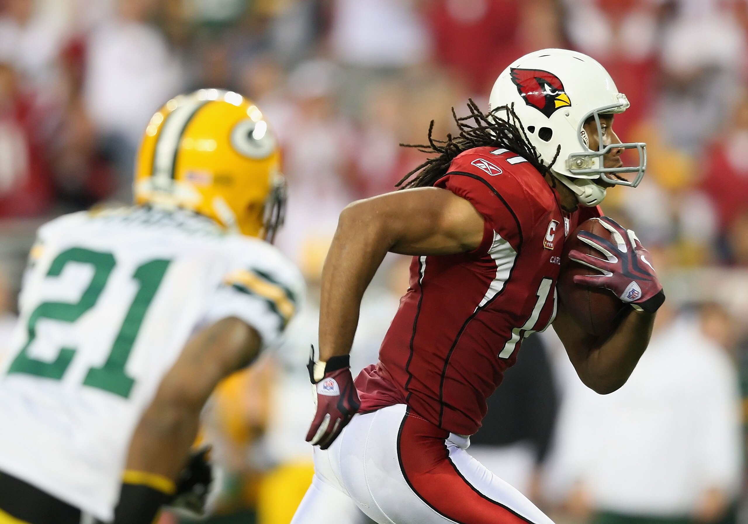 GLENDALE, AZ - JANUARY 10:  Wide receiver Larry Fitzgerald #11 of the Arizona Cardinals runs with the for a touchdown reception during the 2010 NFC wild-card playoff game against  the Green Bay Packers at the Universtity of Phoenix Stadium on January 10,