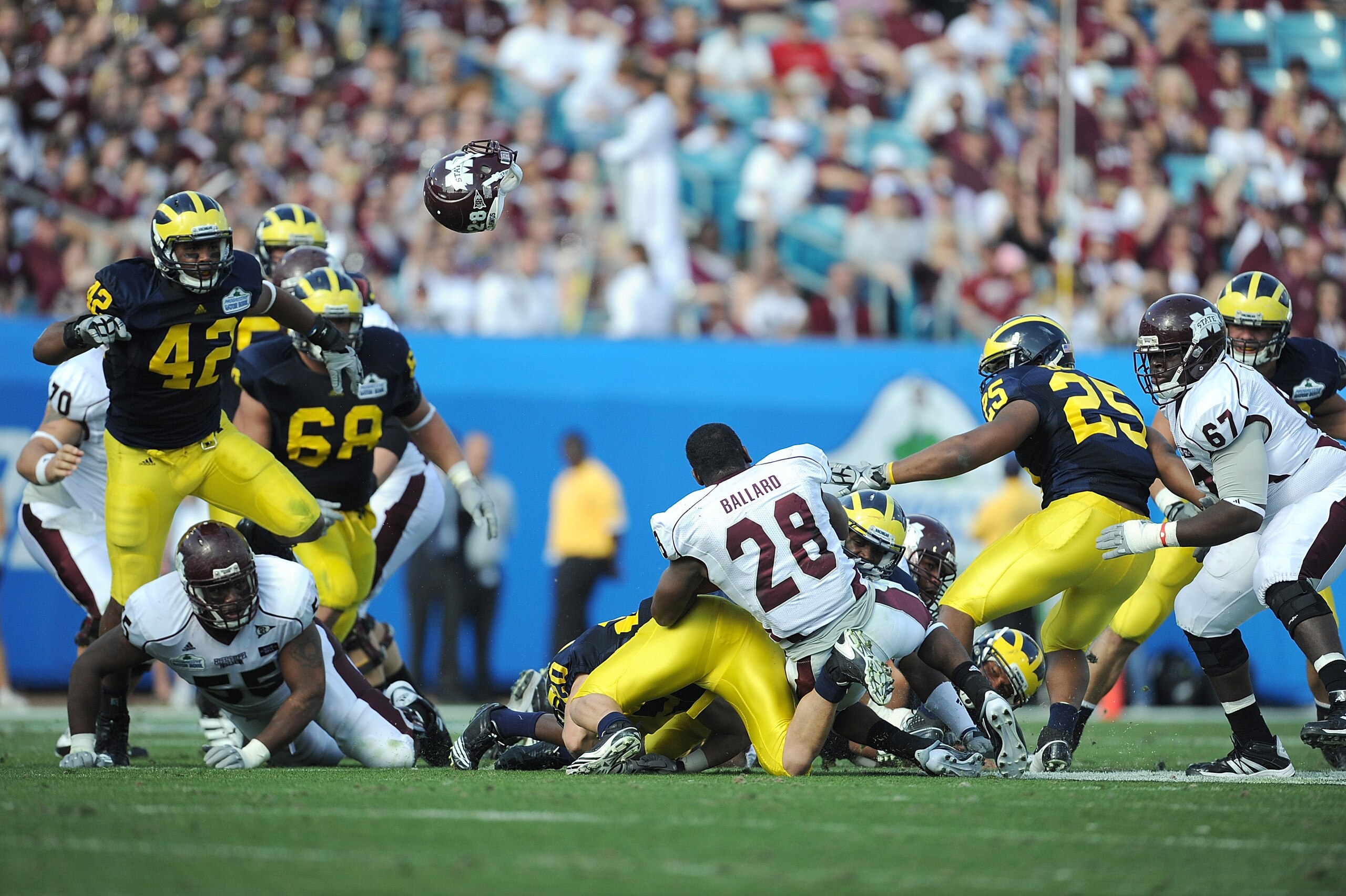 JACKSONVILLE, FL - JANUARY 01:  Running back Vick Ballard #28 of the Mississippi State Bulldogs has his helmet knocked off while being tackled by the Michigan Wolverines during the Gator Bowl at EverBank Field on January 1, 2011 in Jacksonville, Florida