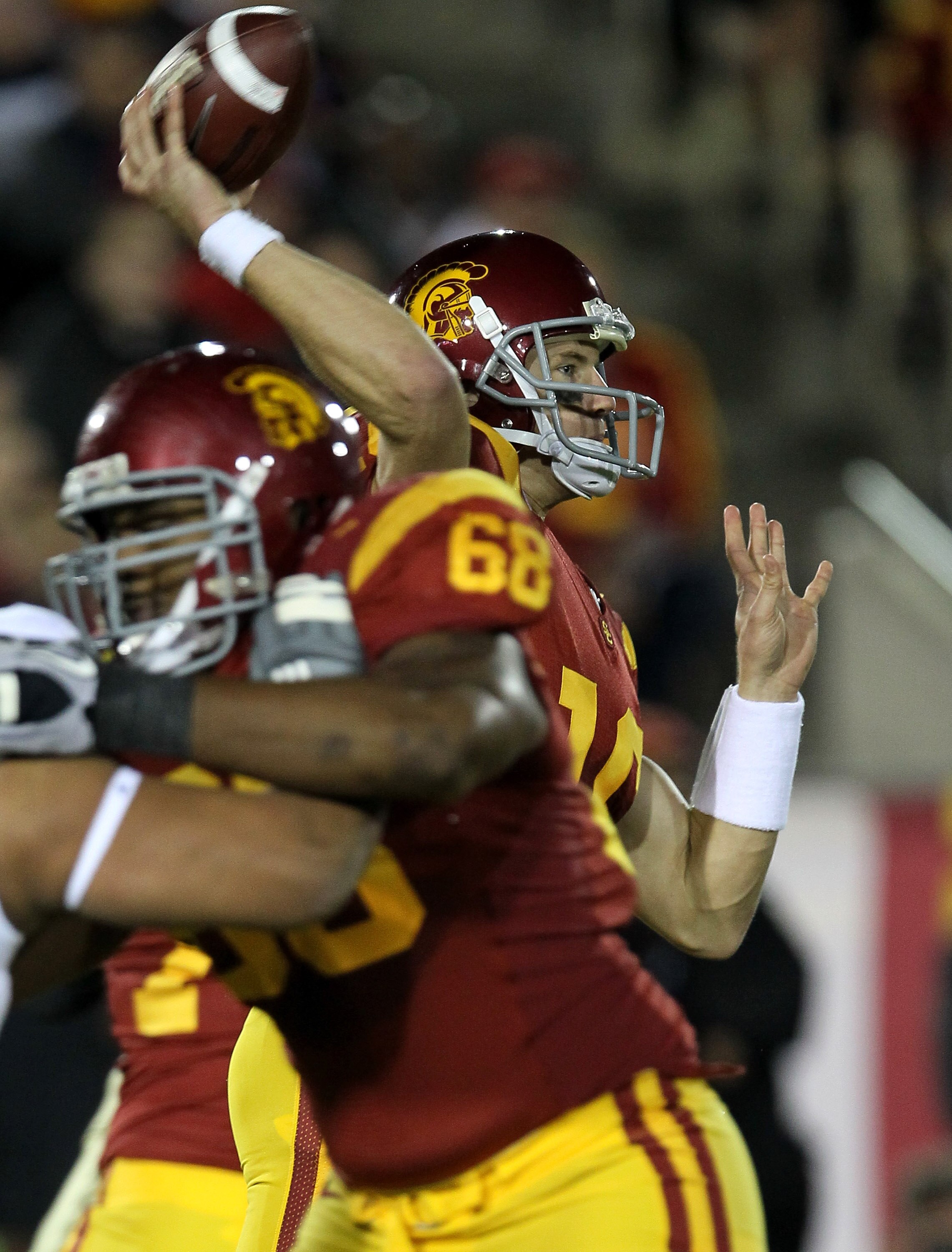 LOS ANGELES - NOVEMBER 27:   Quarterback Mitch Mustain #16 of the USC Trojans throws a pass against the Notre Dame Fighting Irish behind the block of tackle Butch Lewis #68 at the Los Angeles Memorial Coliseum on November 27, 2010 in Los Angeles, Californ