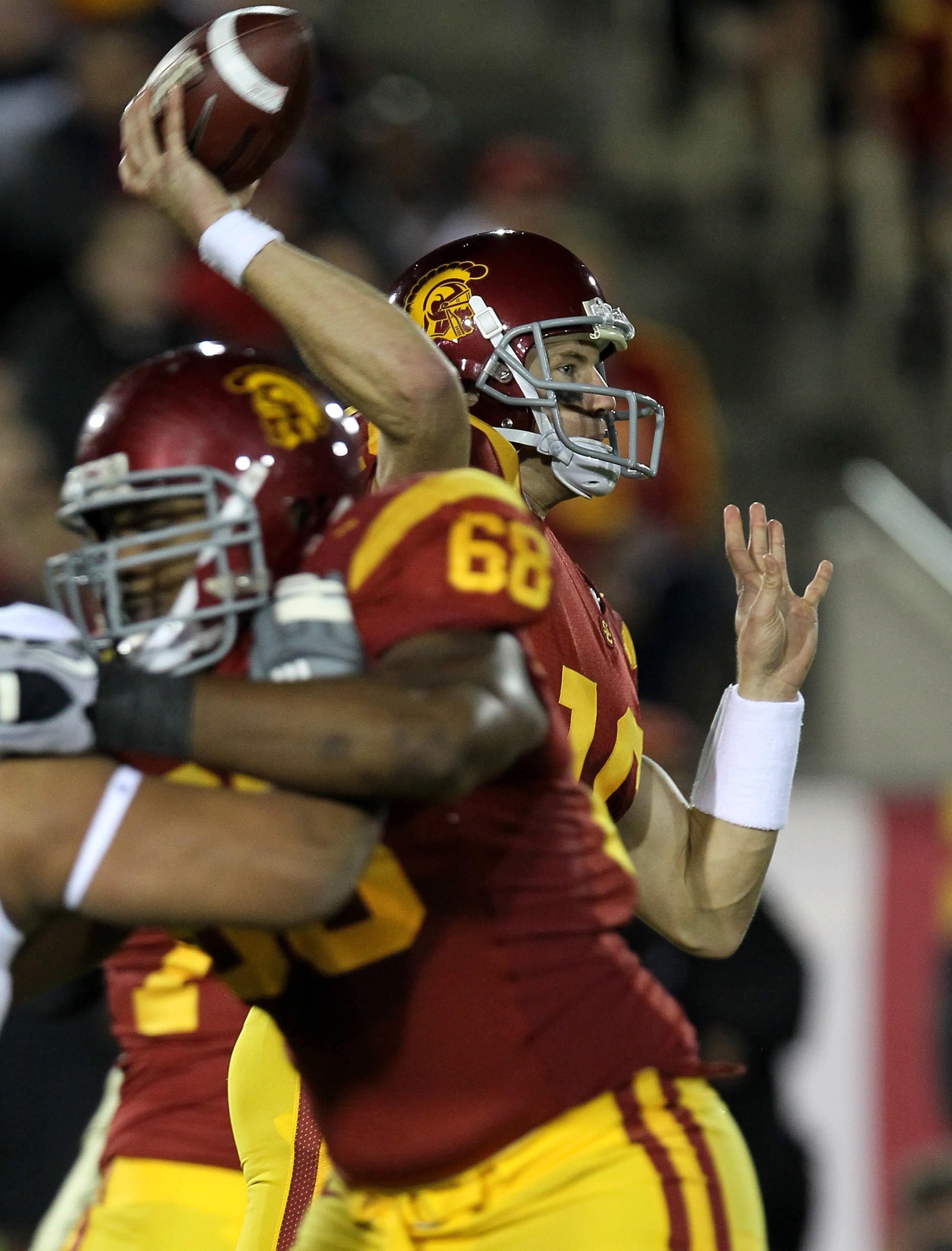 LOS ANGELES - NOVEMBER 27:   Quarterback Mitch Mustain #16 of the USC Trojans throws a pass against the Notre Dame Fighting Irish behind the block of tackle Butch Lewis #68 at the Los Angeles Memorial Coliseum on November 27, 2010 in Los Angeles, Californ