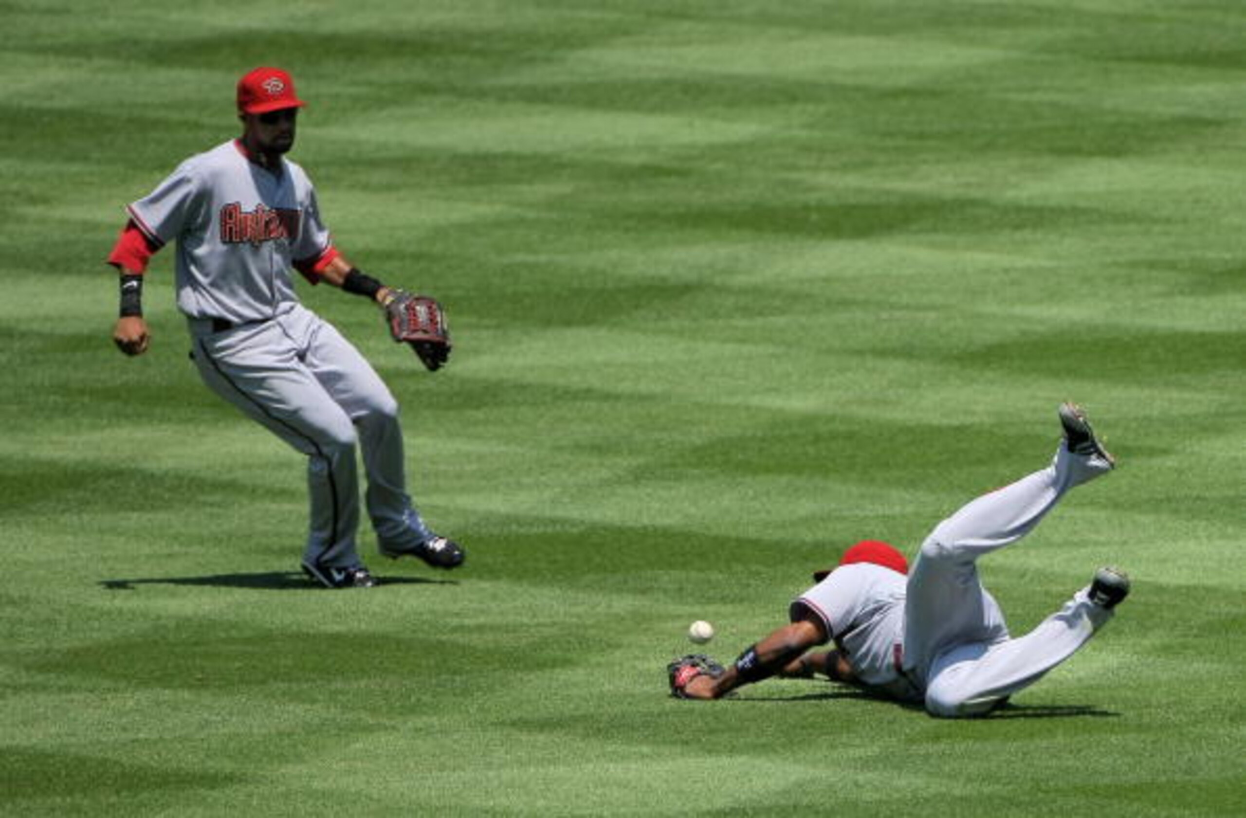 DENVER - JULY 22: Rightfielder Justin Upton #10 of the Arizona Diamondbacks fails to make a sliding catch on a line drive by Carlos Gonzalez of the Colorado Rockies as centerfielder Chris Young #24 backs up the play during MLB action at Coors Field on Ju DENVER - JULY 22: Rightfielder Justin Upton #10 of the Arizona Diamondbacks fails to make a sliding catch on a line drive by Carlos Gonzalez of the Colorado Rockies as centerfielder Chris Young #24 backs up the play during MLB action at Coors Field on Ju