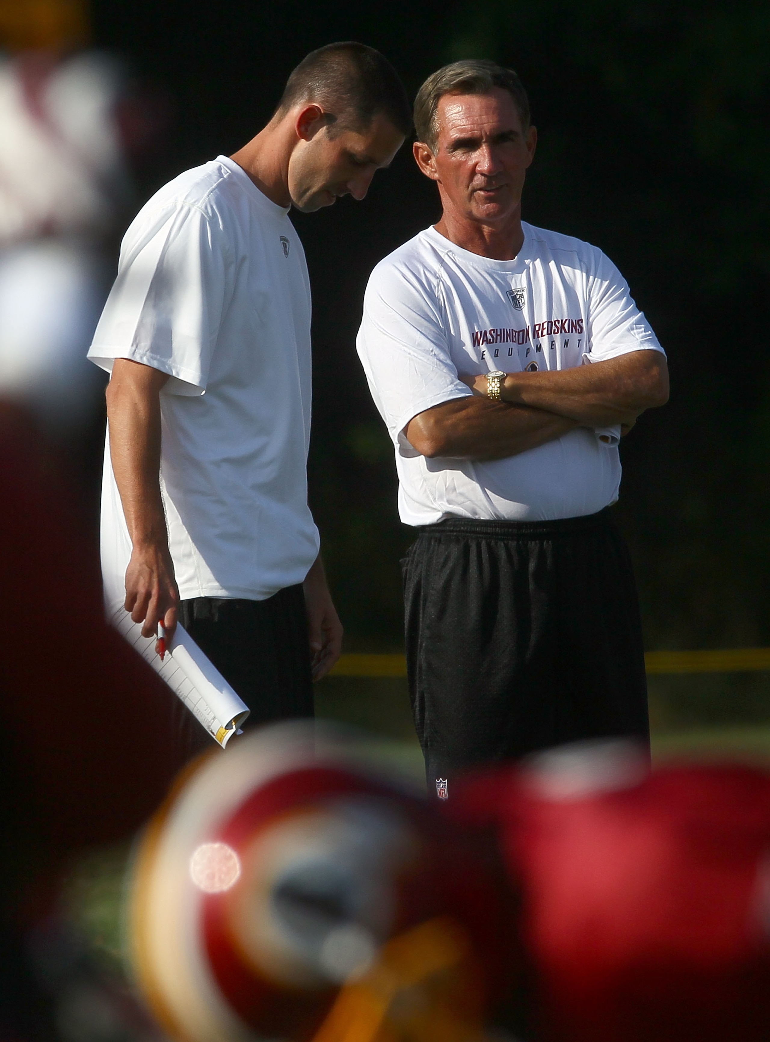 ASHBURN, VA - JULY 30:  Head coach Mike Shanahan (R) of the Washington Redskins speaks with his son and offensive coordinator, Kyle Shanahan (L), during the second day of training camp July 30, 2010 in Ashburn, Virginia.  (Photo by Win McNamee/Getty Image