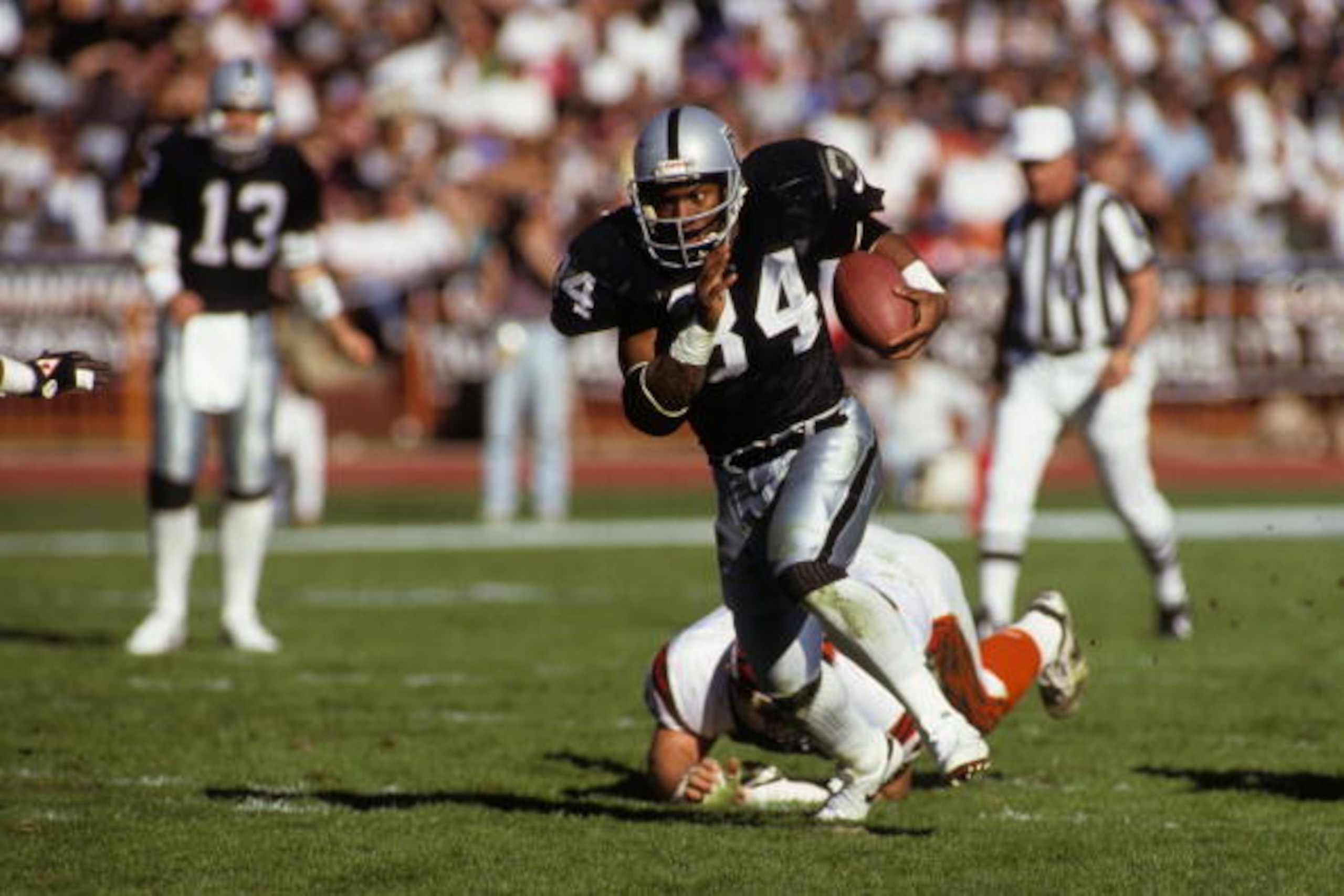 LOS ANGELES - JANUARY 13:  Running back Bo Jackson #34 of Los Angeles Raiders breaks free on the open field against the Cincinnati Bengals defense during the 1990 AFC Divisional Playoffs at the Los Angeles Memorial Coliseum on January 13, 1991 in Los Ange