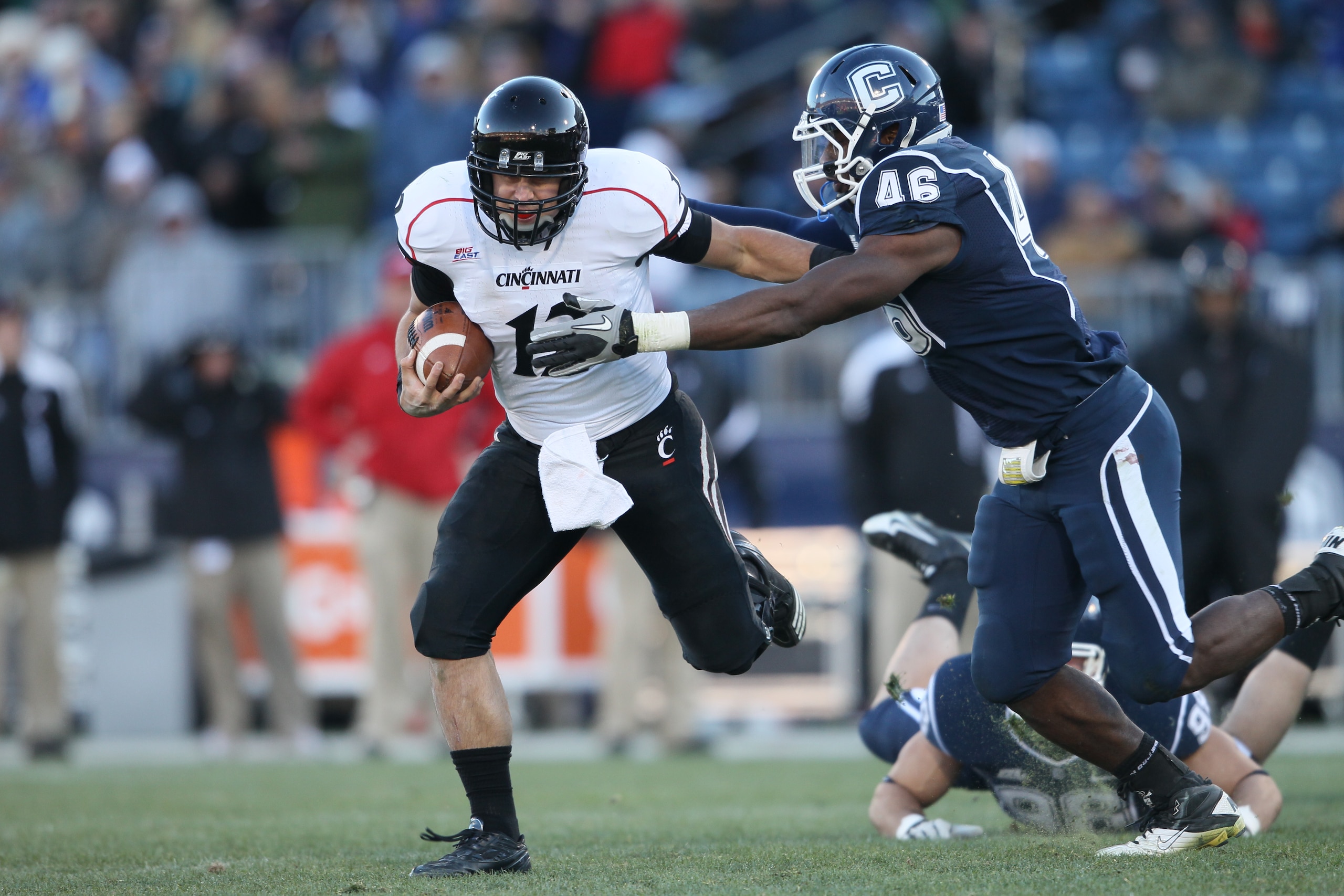 EAST HARTFORD, CT - NOVEMBER 27:  Zach Collaros #12 of the Cincinnati Bearcats carries the ball as Sio Moore #46 of the Connecticut Huskies makes the tackle on November 27, 2010 at Rentschler Field in East Hartford, Connecticut. The Huskies defeated the B