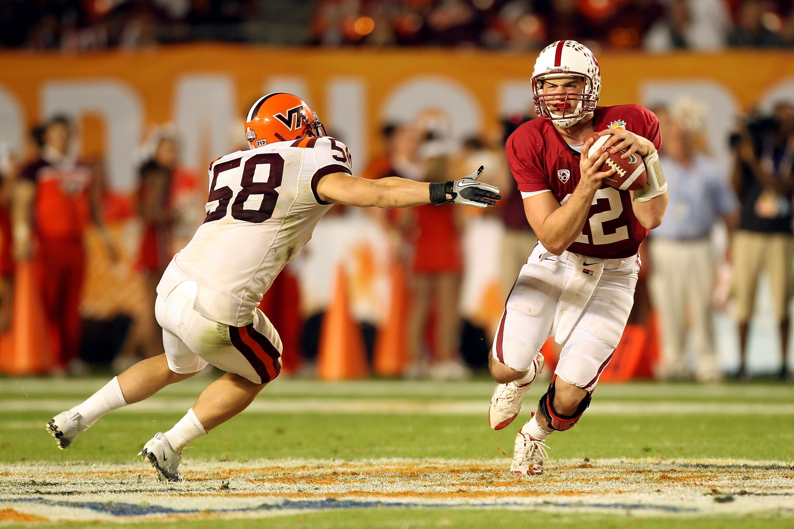 MIAMI, FL - JANUARY 03: Andrew Luck #12 of the Stanford Cardinal ellude Jack Tyler #58 of the Virginia Tech Hokies during the 2011 Discover Orange Bowl at Sun Life Stadium on January 3, 2011 in Miami, Florida. STanford won 40-12. (Photo by Mike Ehrmann/Ge