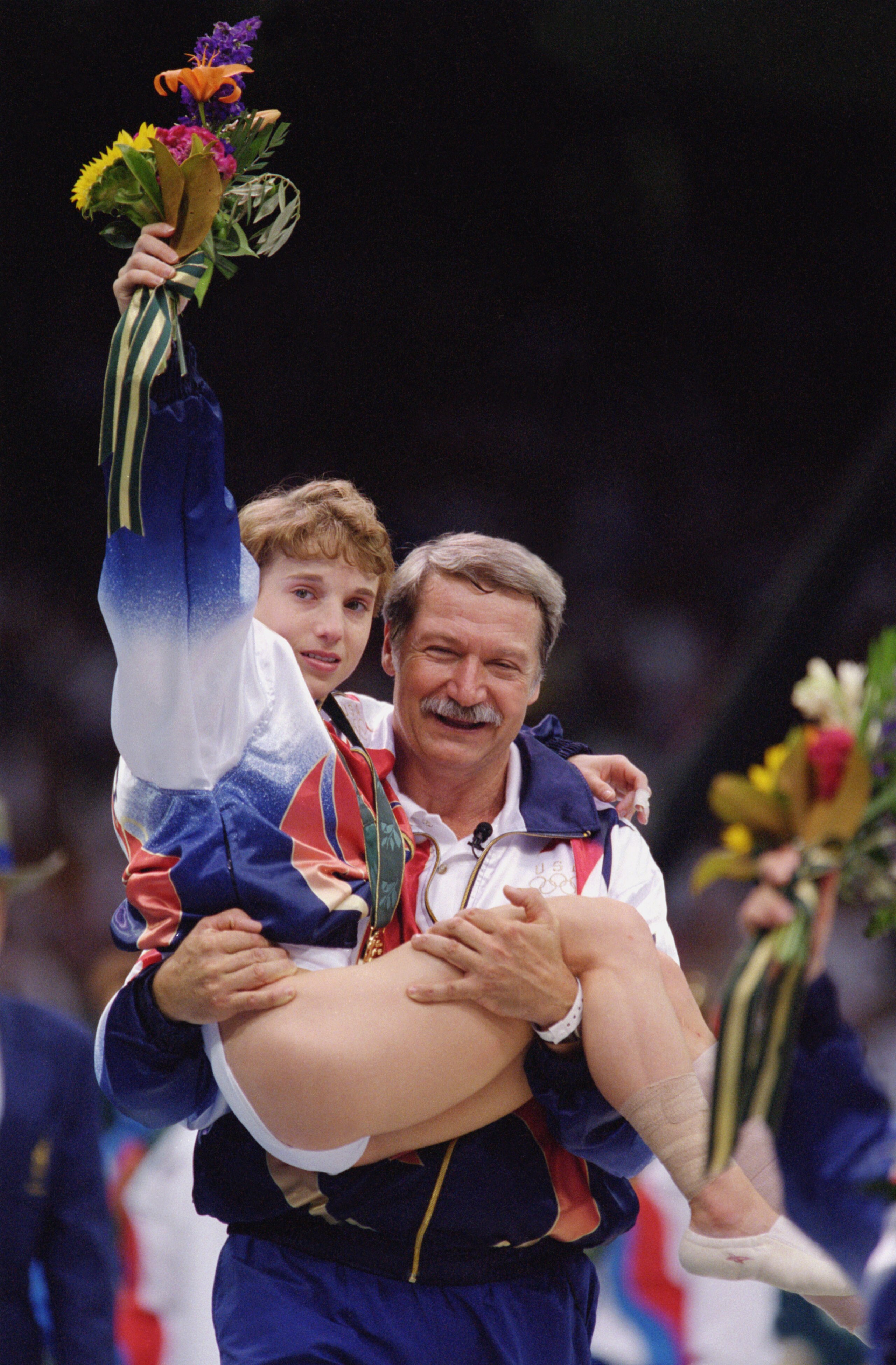 ATLANTA - JULY 23:  Coach Bela Karolyi carries an injured yet triumphant Kerri Strug of the United States after she received her gold medal in the Womens Team Gymnastics competition at the 1996 Olympic Games on July 23, 1996 at the Georgia Dome in Atlanta