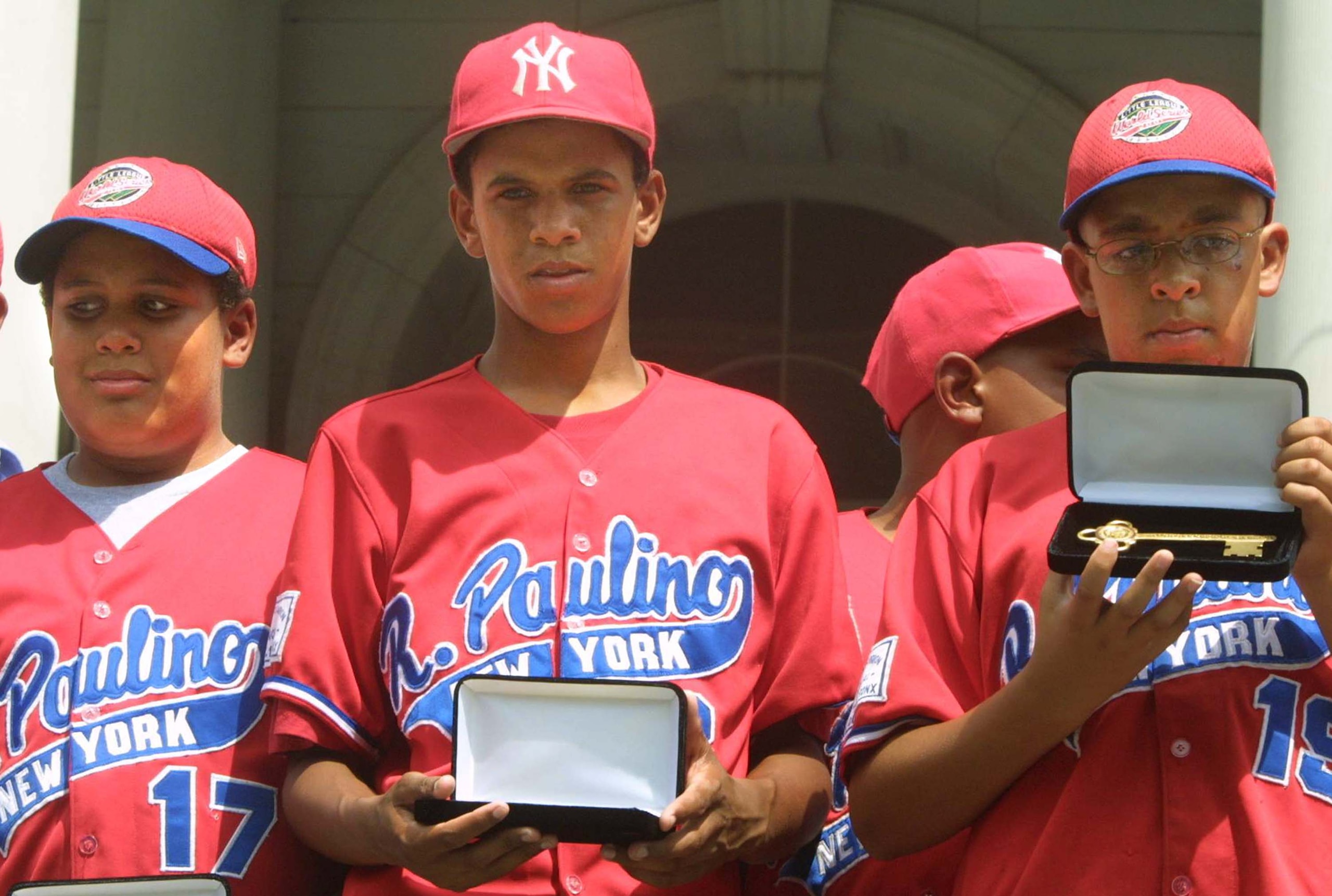 393788 05: (FILE PHOTO) Danny Almonte (C) and other members of the Rolando Paulino All-Stars Bronx Little League baseball team hold their keys to the city during a ceremony honoring the team August 28, 2001 in New York City. Dominican Republic officials s