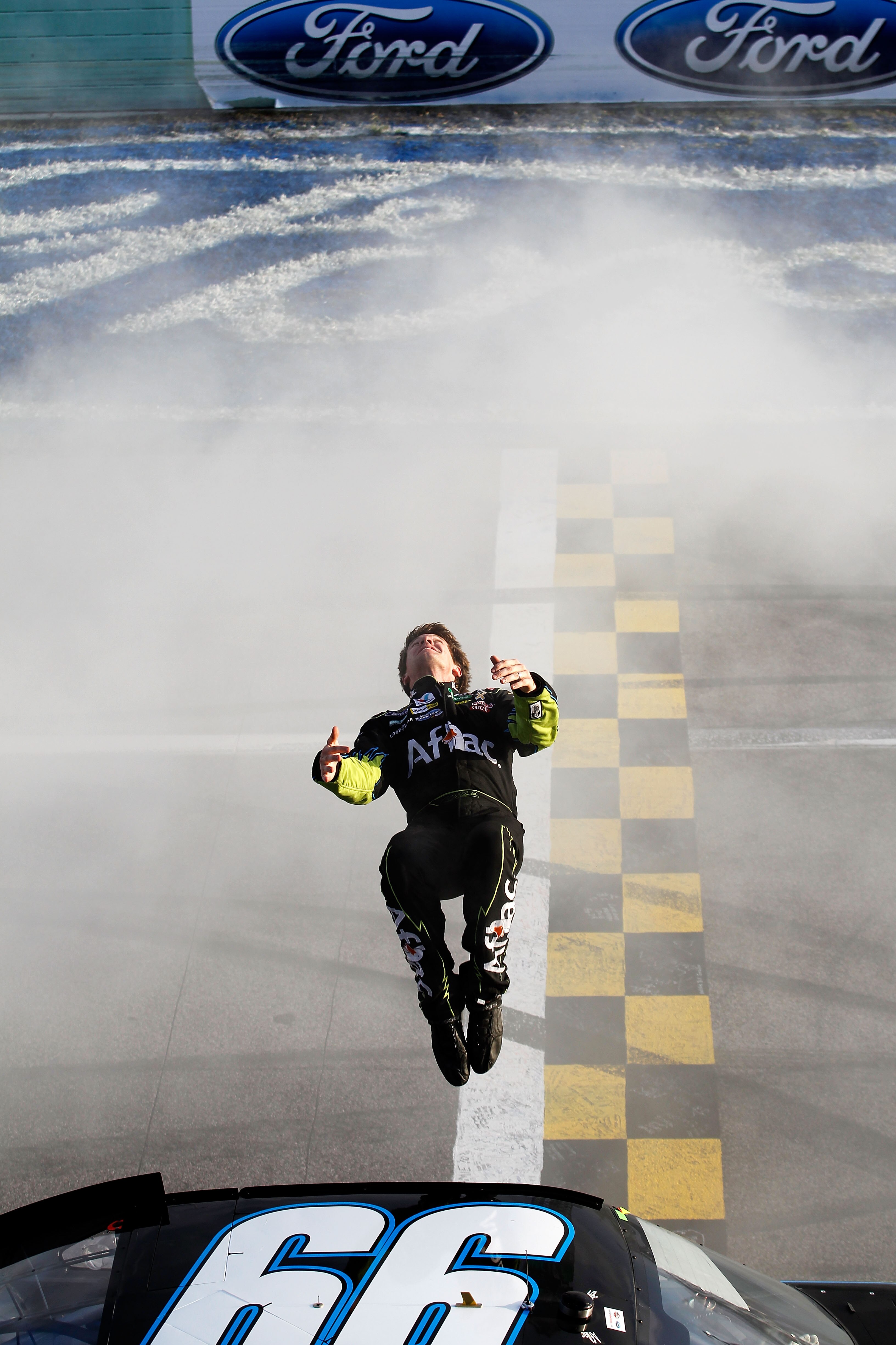 HOMESTEAD, FL - NOVEMBER 21:  Carl Edwards, driver of the #99 Aflac Ford, performs a back flip to celebrate winning the NASCAR Sprint Cup Series Ford 400 at Homestead-Miami Speedway on November 21, 2010 in Homestead, Florida.  (Photo by Todd Warshaw/Getty