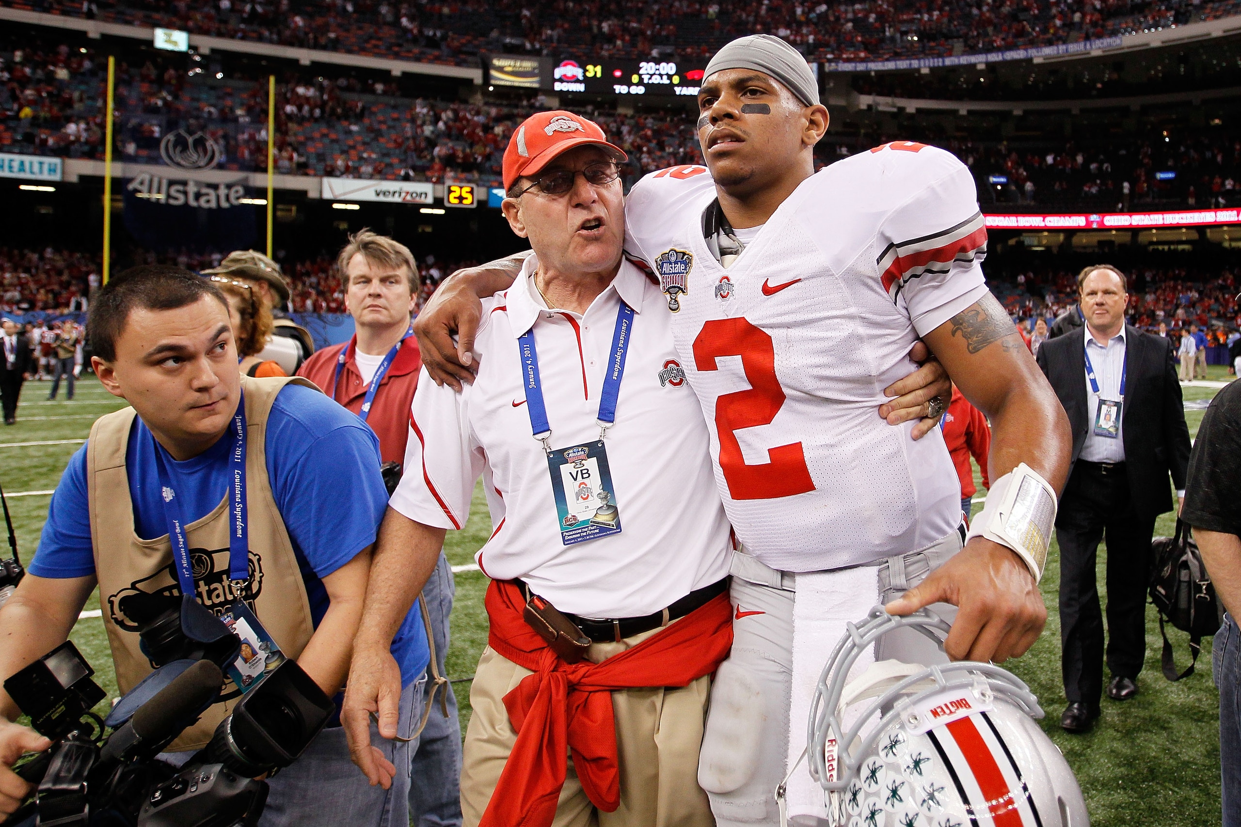 NEW ORLEANS, LA - JANUARY 04:  (M) Quarterback Terrelle Pryor #2 of the Ohio State Buckeyes is helped off the field by a member of the Buckeyes support team after the Buckeyes 31-26 victory against the Arkansas Razorbacks during the Allstate Sugar Bowl at