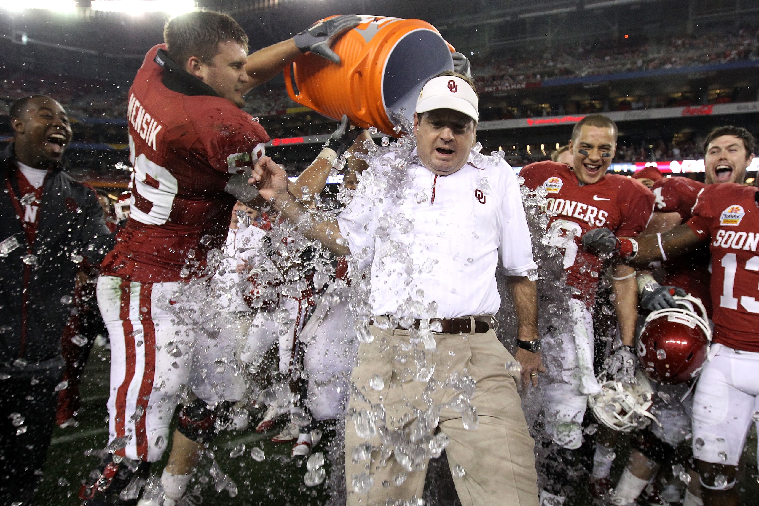 GLENDALE, AZ - JANUARY 01:  Head coach Bob Stoops has a Gatorade bucket dumped on him by Eric Mensik #69 late in the fourth quarter before the Sooners 48-20 victory against the Connecticut Huskies during the Tostitos Fiesta Bowl at the Universtity of Phoe